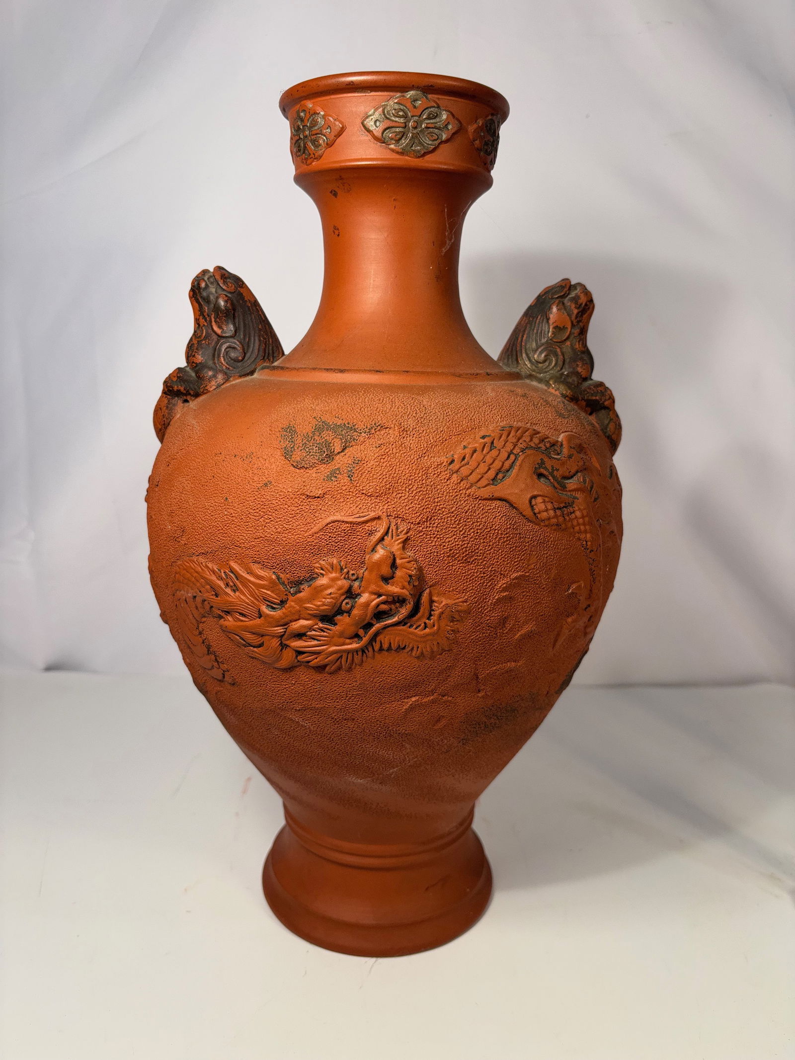 A large Japanese terracotta two handled Vase, Marked “Tsunenaga Namesabur? Seisaku??, Meiji: 19th century, ,A lovely Japanese terracotta two-handled vase dating to the Meiji period (circa 1880). The vase is decorated with molded and painted dragon motifs, featuring stylized dragons applied to