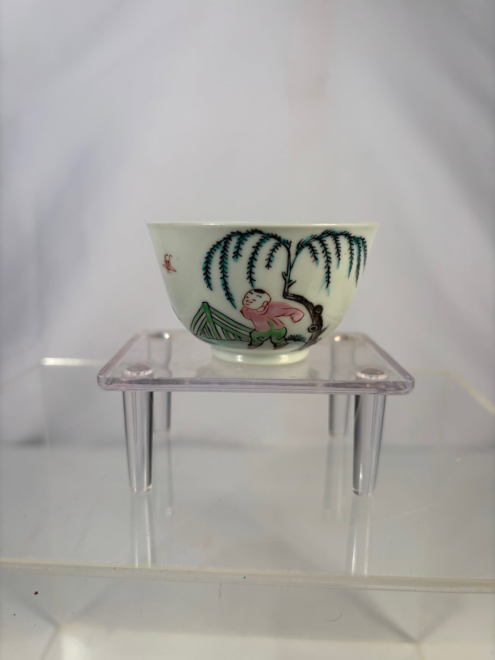 A Chinese Famille-Rose Porcelain Bowl with Child and Willow Scene: Qing dynasty(1644-1912); Chinese famille-rose porcelain bowl, decorated to the exterior with a figural scene depicting a child beneath a willow tree within a garden setting, painted in soft enamel col