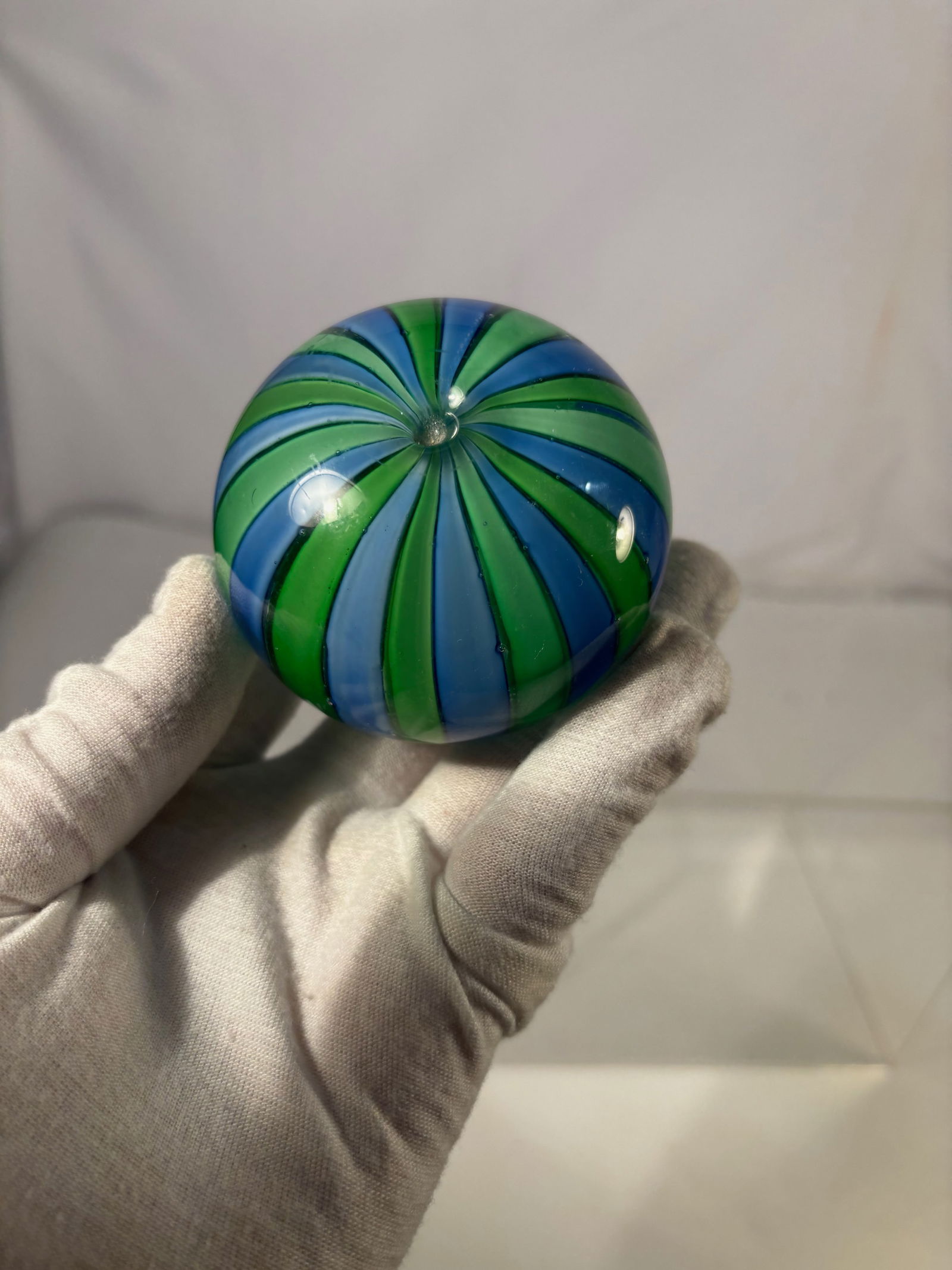 A Italian Murano Style Blue & Green Swirl Art Glass Paperweight: Italian Murano style art glass paperweight featuring alternating blue and green swirling bands radiating from a central point. The bold striped design creates a dynamic spiral visual effect within a s