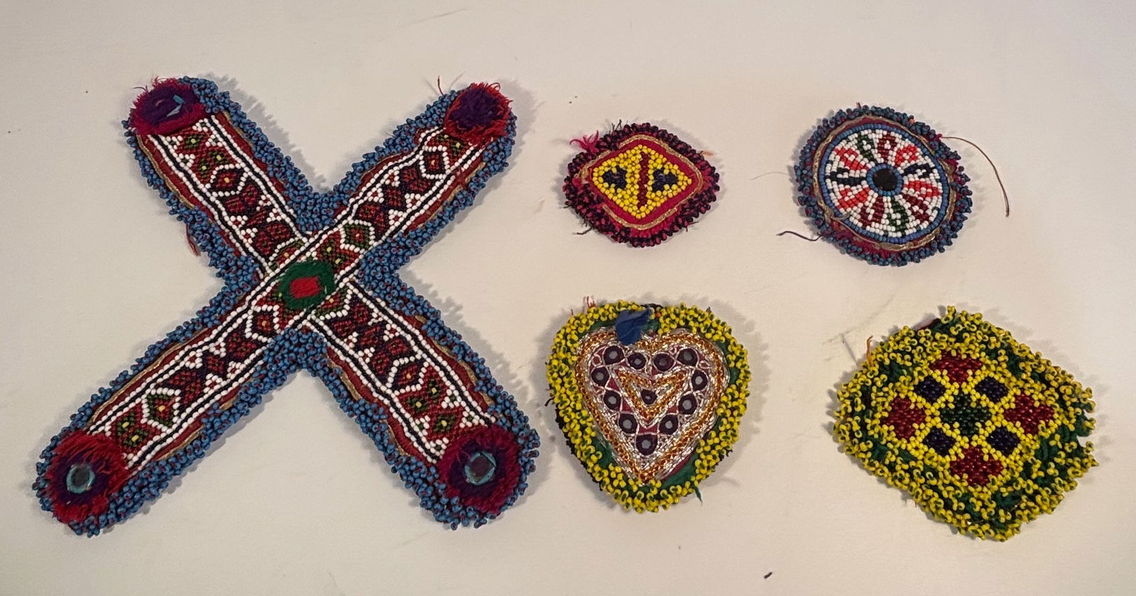 Set of 5 Vintage Afghan/Pakistani Kuchi Beaded Tribal Medallions: A group of five vintage hand-beaded tribal medallions, traditionally known as gul de peron (“dress flowers”) made by the Kuchi tribes of Afghanistan and northern Pakistan. Each piece is skillf