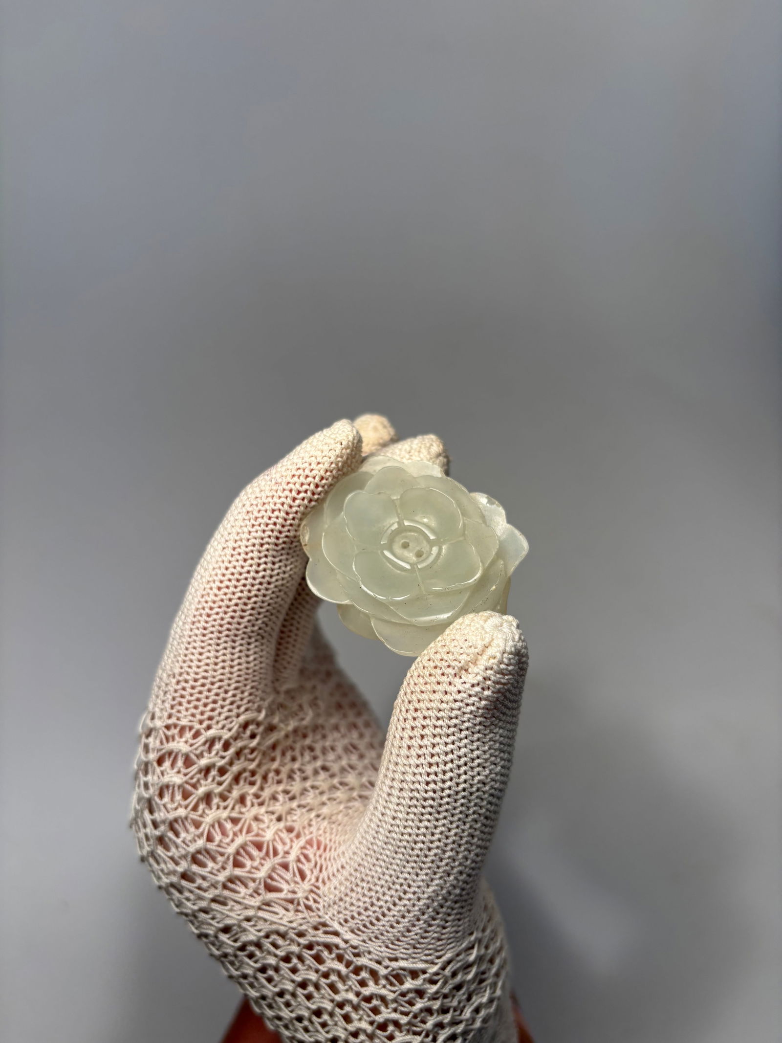 A Chinese naphrite white jade Floral Plaque: Qing dynasty(1644-1912); Carved in the form of a blossoming peony or lotus flower, with layered petals radiating from a central stamen.Dimensions?Length: 1.5 inches; Width: 1.25 inches.