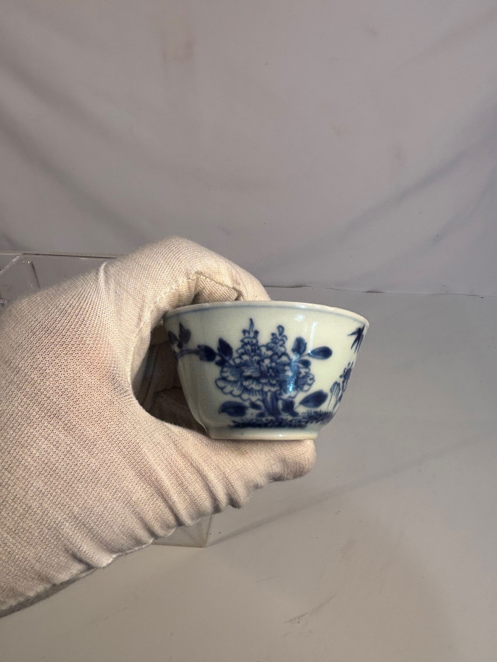 A Chinese Blue and White Porcelain Tea Bowl , Qing Dynasty, 18th Century: A fine blue and white porcelain tea bowl, Qing Dynasty, 18th century. The exterior delicately painted in underglaze blue with bamboo, rockwork, and floral sprays, framed by a patterned border along th