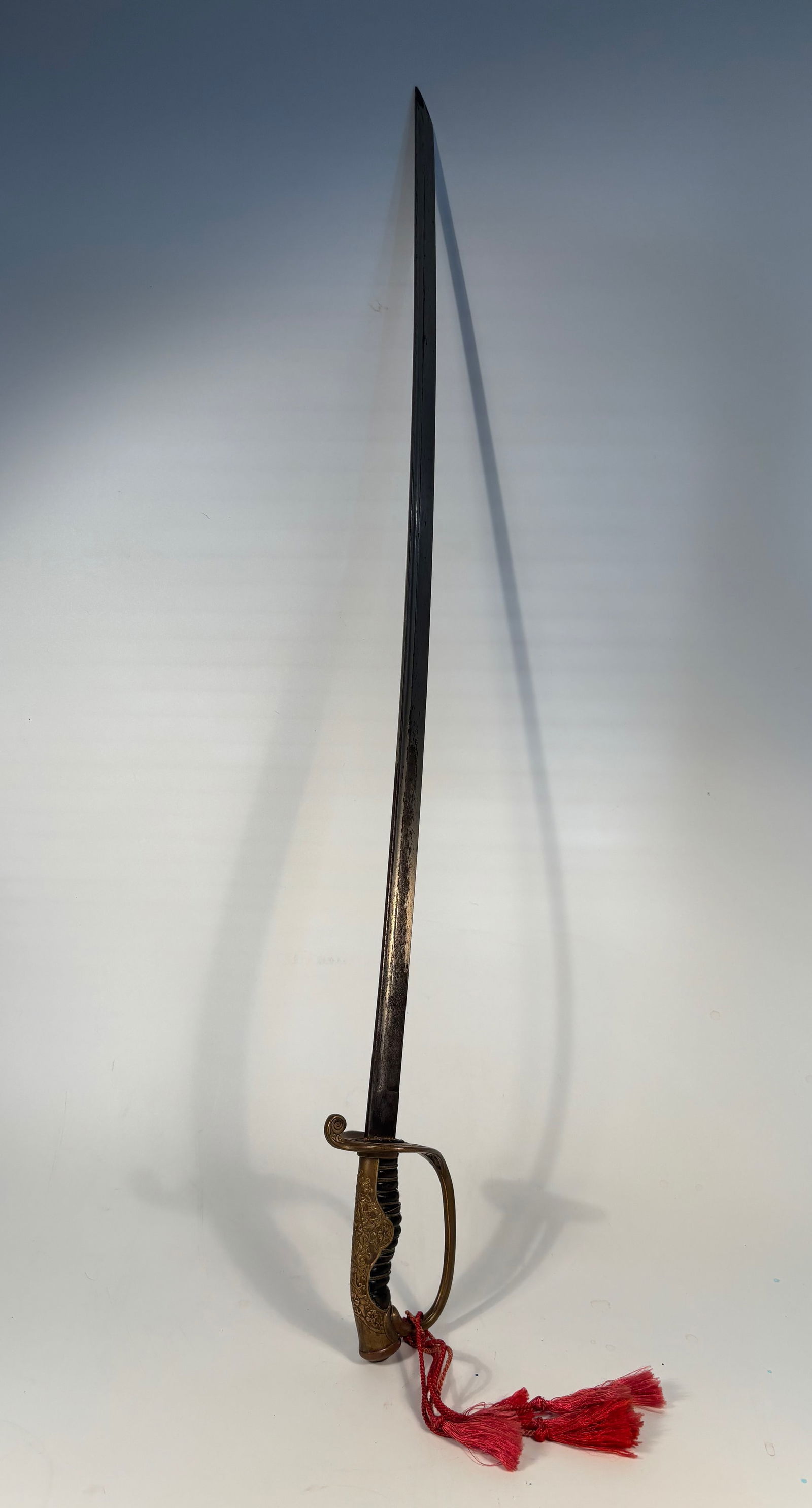 A Japanese WWII Police Sword: Very nice Japanese World War II era police sword with a beautiful hilt with profuse engraving on back strap. Scabbard in good condition with a couple depressions towards the drag. Blade it's nice and