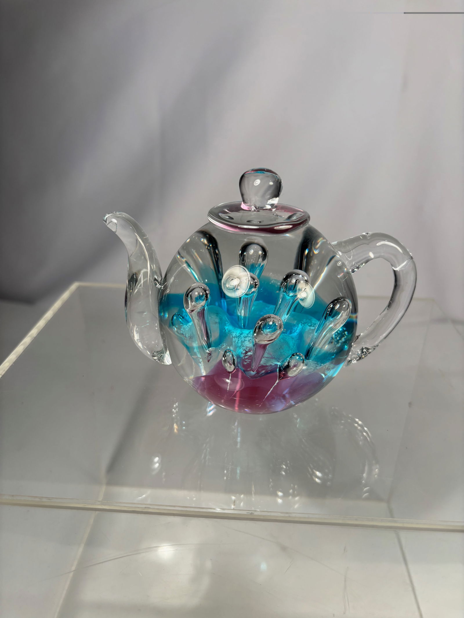 Art Glass Teapot Form Paperweight with Blue and Purple Interior: Decorative art glass paperweight formed as a miniature teapot. The clear blown glass body is embellished with applied glass droplets and features a vibrant blue and purple interior creating a layered,