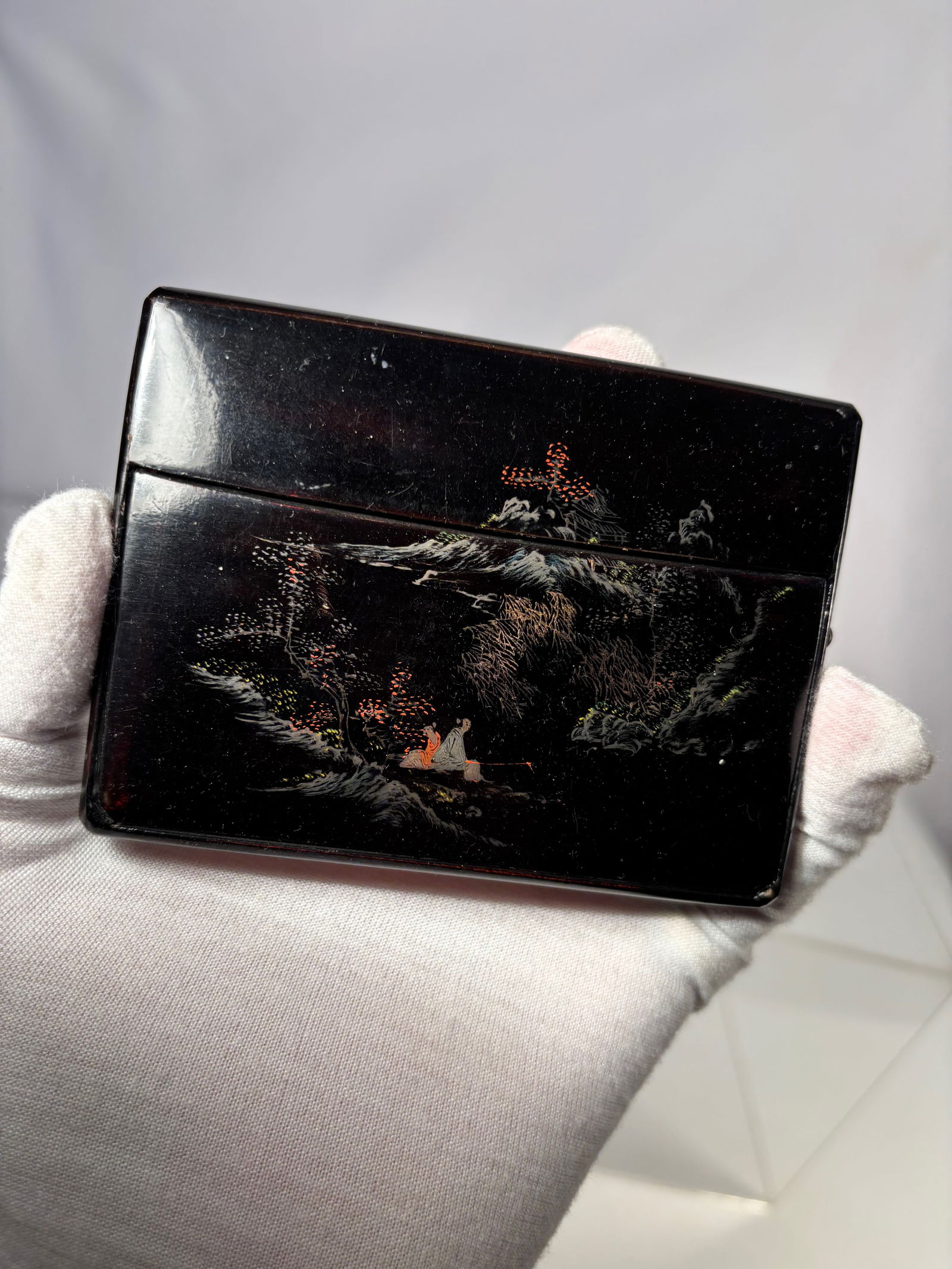 A Chinese Fujian Lacquer Business Card Case, Marked “Min Qi: Black lacquer business card case decorated with gilt landscape and figures in traditional style. Folding stand design. Base with decorative mark reading “Min Qi” (Fujian ware), indicating prod