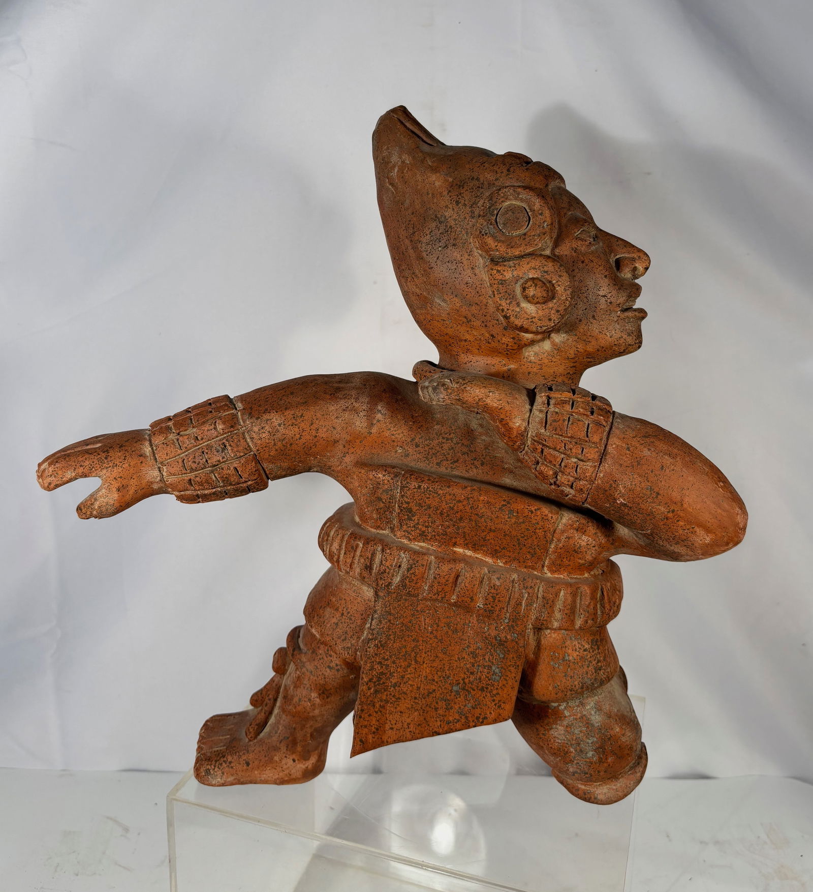 Redware Ceramic Warrior Figure, Mexico, in Pre-Columbian Style: A redware ceramic figure rendered in the distinctive style of West Mexican ancient sculpture, depicting a kneeling warrior with a crested headdress, ear ornaments, and a detailed beaded collar. The fi