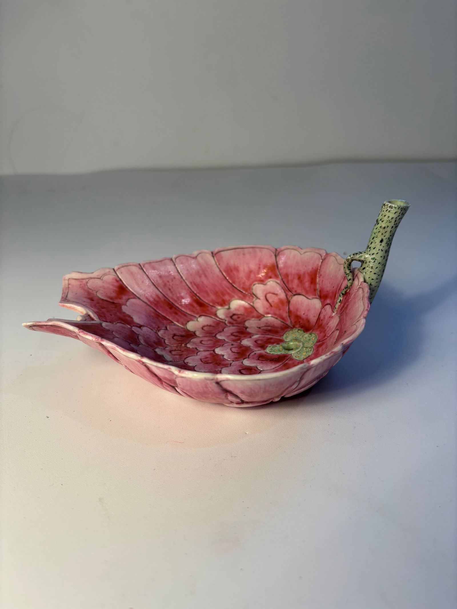 A Chinese Famille-Rose "LOTUS" Water Dropper: Early 20th century ; This is modeled as a teardrop-shaped shallow dish with rounded sides rising to a scalloped edge and painted all-over with variegated pink lotus petals, the petals parting at the p