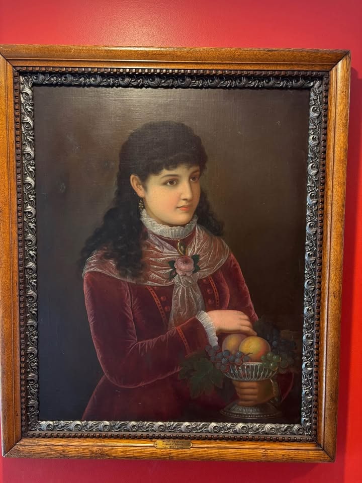 Malí? Knobloch (Czech, 19th Century), Oil on Canvas Portrait of a Young Woman with Fruit, 1880: Oil on canvas portrait of a young woman dressed in a rich crimson velvet gown with lace collar and floral brooch, shown holding a silver compote filled with grapes and peaches. The sitter is presented