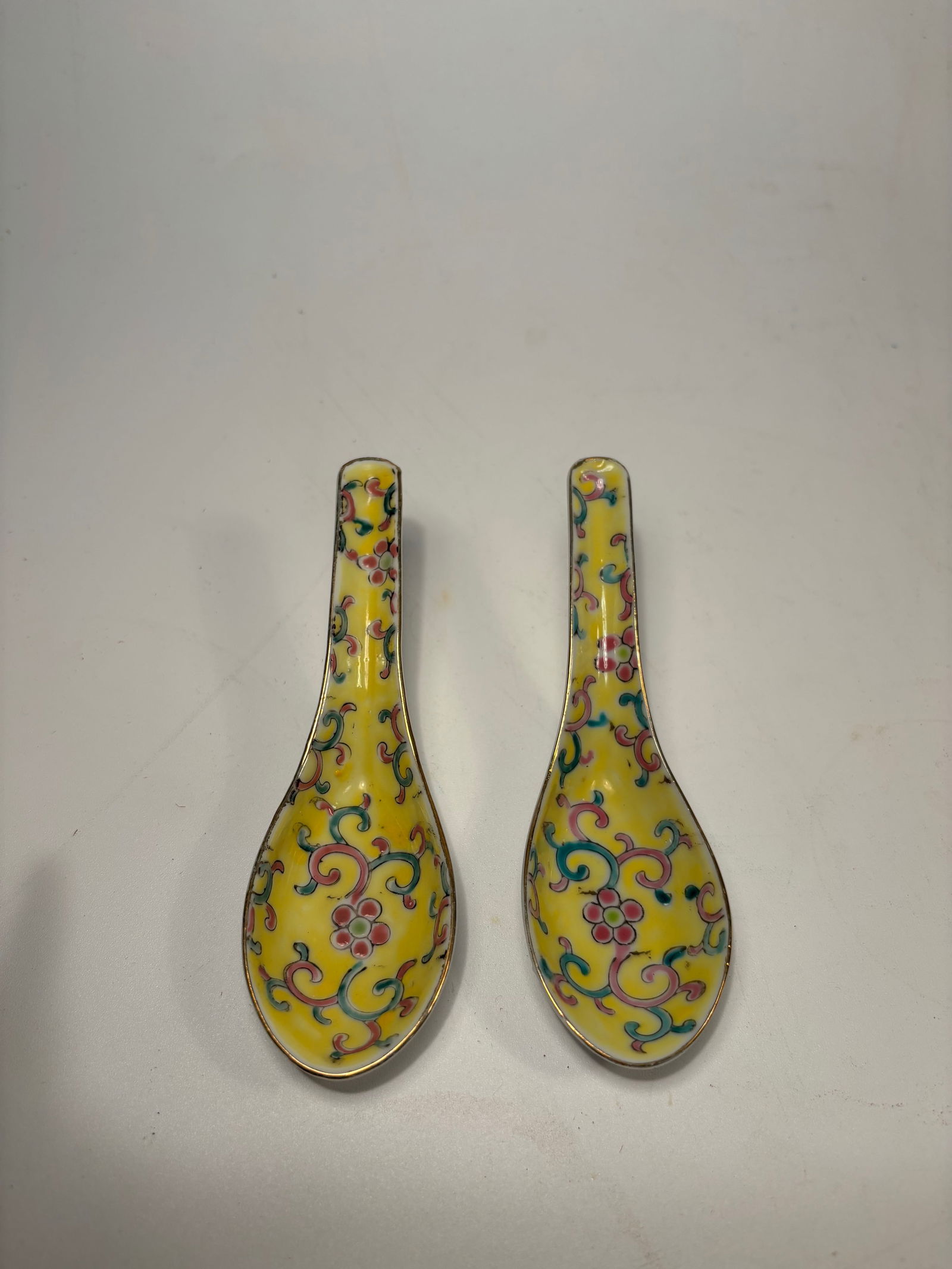 A pair of Chinese Famille Jaune-Style Porcelain spoons with mark: Republic period (1912-1949) ; Each finely enameled on a bright yellow ground with colorful scrolling lotus and foliage motifs in the Qing dynasty style. Dimensions?Length: 5.5 inches.