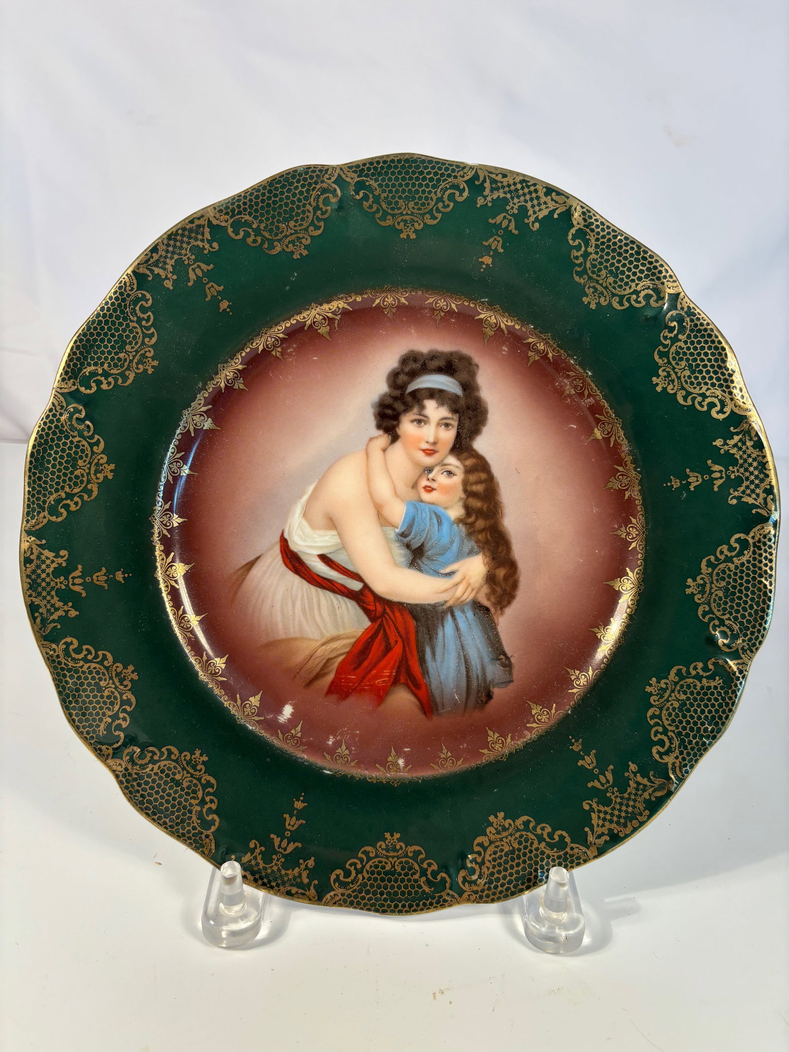 R.S. Prussia Porcelain Plate with Woman and Child Scenic Decoration: Early 20th-century R.S. Prussia porcelain plate, the center finely decorated with a scenic image of a woman and child in a pastoral setting, framed by a molded and gilded border. Reverse with the crow