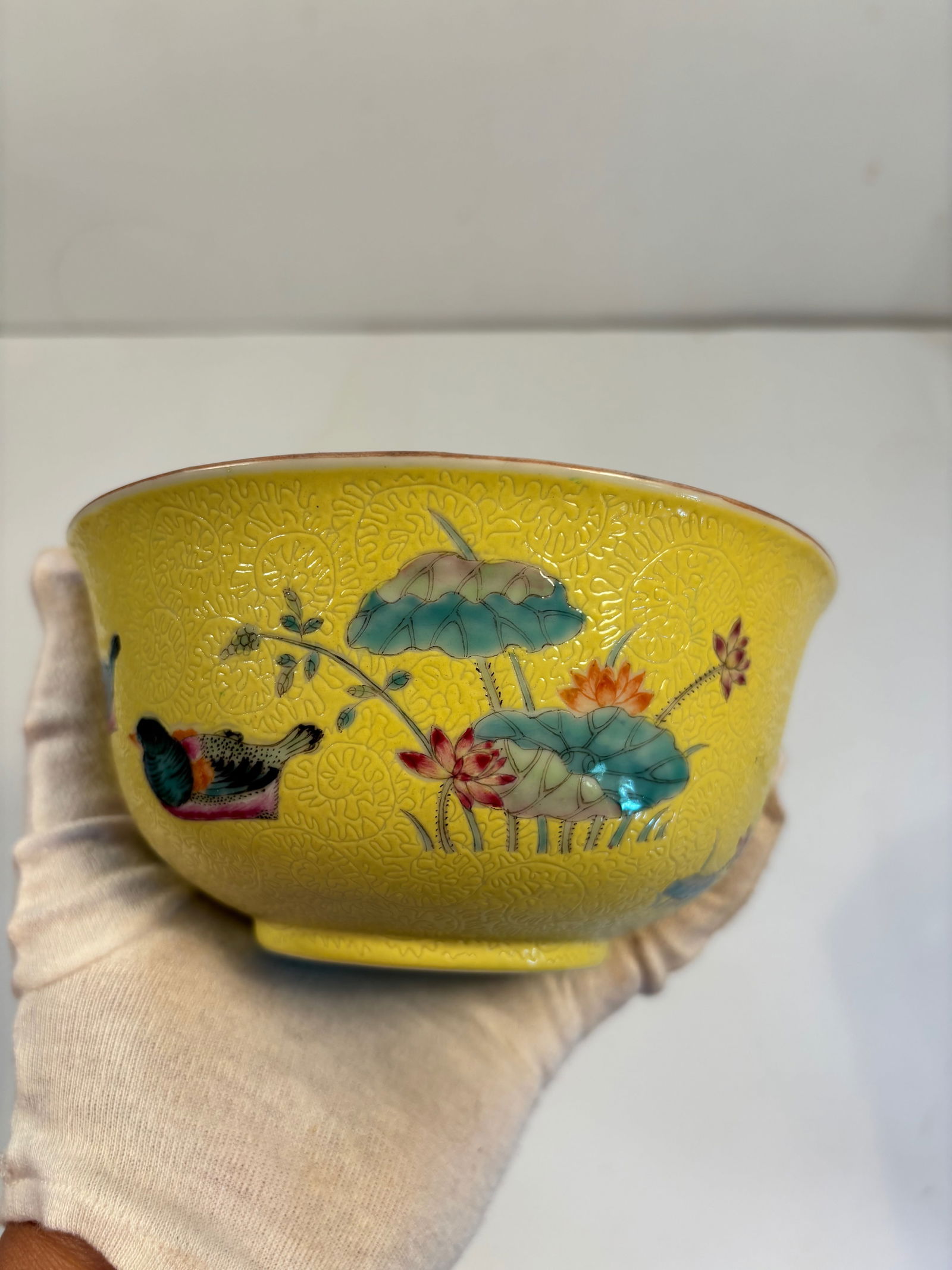 A Chinese famille rose yellow ground porcelain bowl with "QIANLONG" iron red mark: Late 19th to early 20th , The yellow ground with famille rose enameling and birds among lotus plants is very much in the aesthetic of imperial porcelain. Dimensions?Diameter: 6 inches; Height: 3 inche