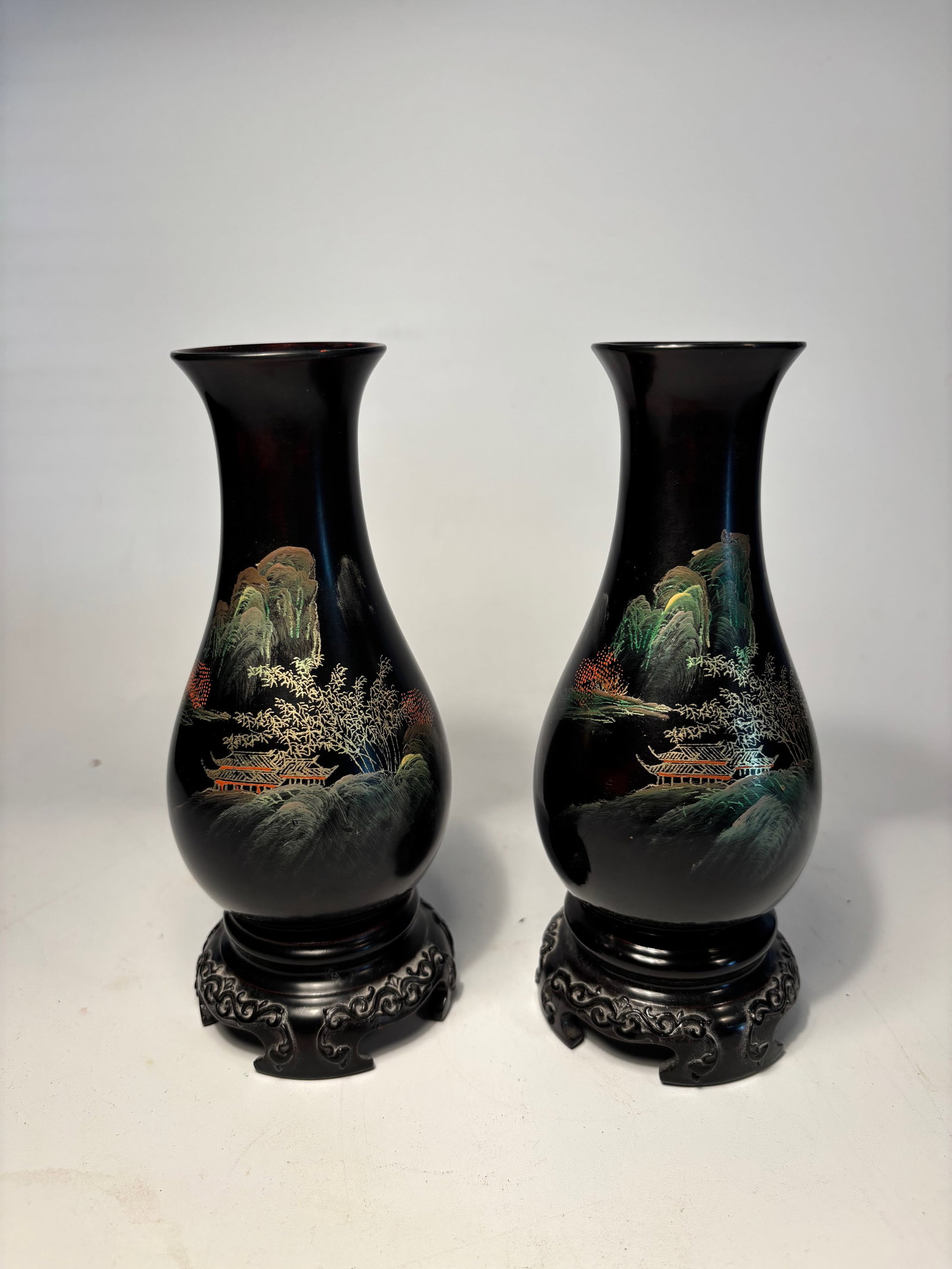 Pair of Chinese Black Lacquered Vases with Hand-Painted Landscape: 20th century; A pair of elegant Chinese vases with flared rims and ovoid bodies, each finished in a glossy black ground and finely hand-painted with detailed mountain landscapes, foliage, and traditio