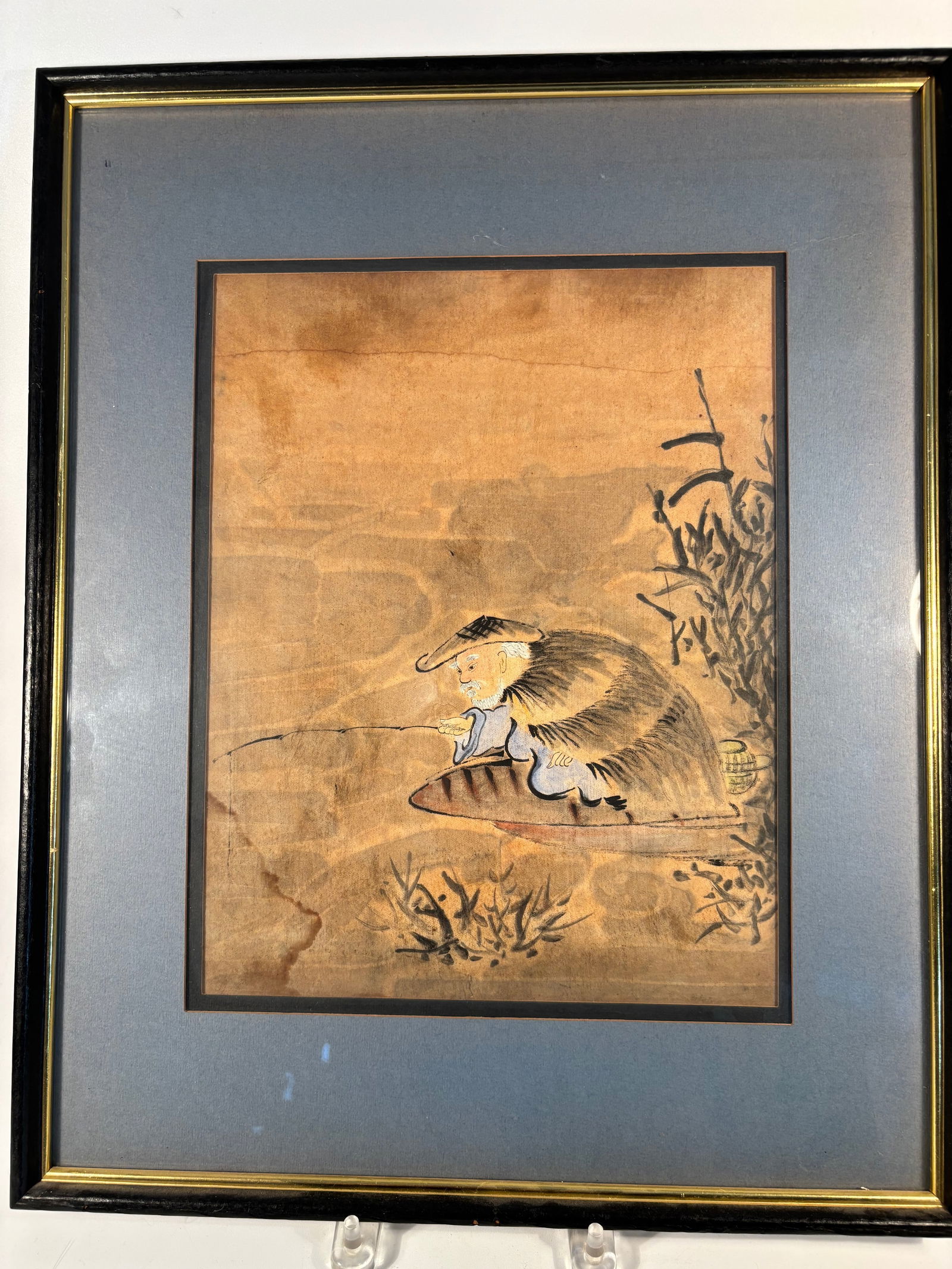 A Japanese Meiji Period Watercolor painting "Elderly Fisherman in Straw Cape with Fishing Rod": A delicate Japanese watercolor and ink painting on paper, likely dating to the Meiji period (1868–1912), depicting an elderly fisherman seated on a small wooden boat. The figure wears a traditional