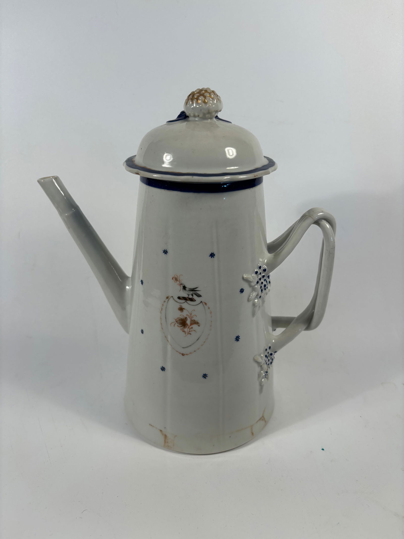 A Chinese export porcelain coffee pot: Qianlong period (1736-1795); Tall cylindrical body with a long spout and side handle; The knop (lid handle) resembles a peach or flower bud, a common decorative element on export porcelain.Dimensions?