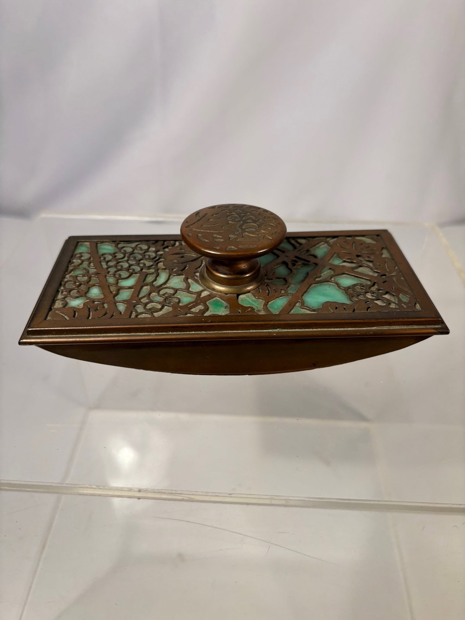 A Tiffany Studios New York Grapevine Gilt Bronze Rocker Blotter with Green Favrile Glass, No. 995: A Tiffany Studios grapevine-pattern gilt bronze rocker blotter, New York, early 20th century. The rectangular blotter plate is decorated with pierced grapevine and foliate motifs in the Art Nouveau ta