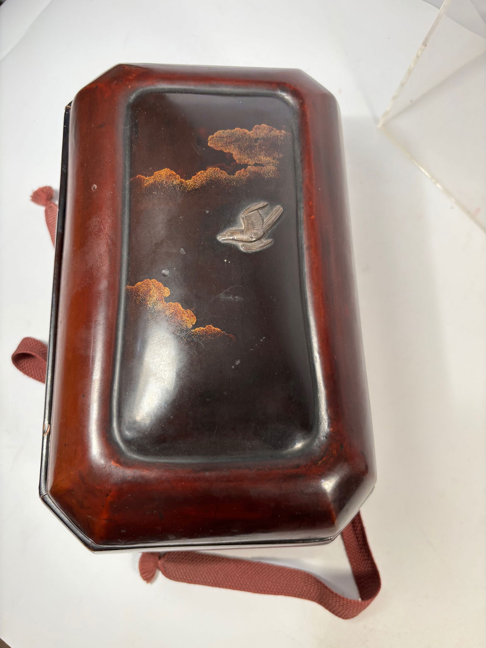 A Japanese Meiji Lacquer Bunko Document Box with Maki-e Clouds & Raden Bird: Meiji period (1868–1912). Japanese lacquer document box (bunko) decorated with maki-e gold clouds and a raden mother-of-pearl bird motif. The interior fitted with patterned silk brocade lining. Heig