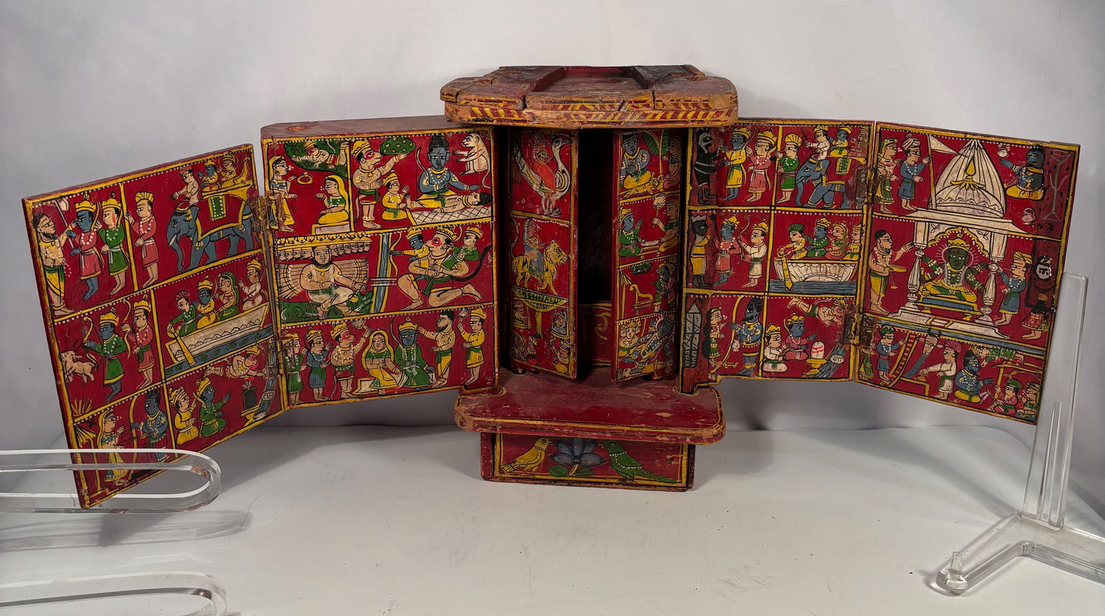 A Painted Indian Storytelling Shrine Depicting Vishnu, Rama, and Krishna: Early 20th century; Portable painted wooden storytelling shrine from India, traditionally used by a bhat (itinerant storyteller). The folding panels and doors are decorated with approximately seventy