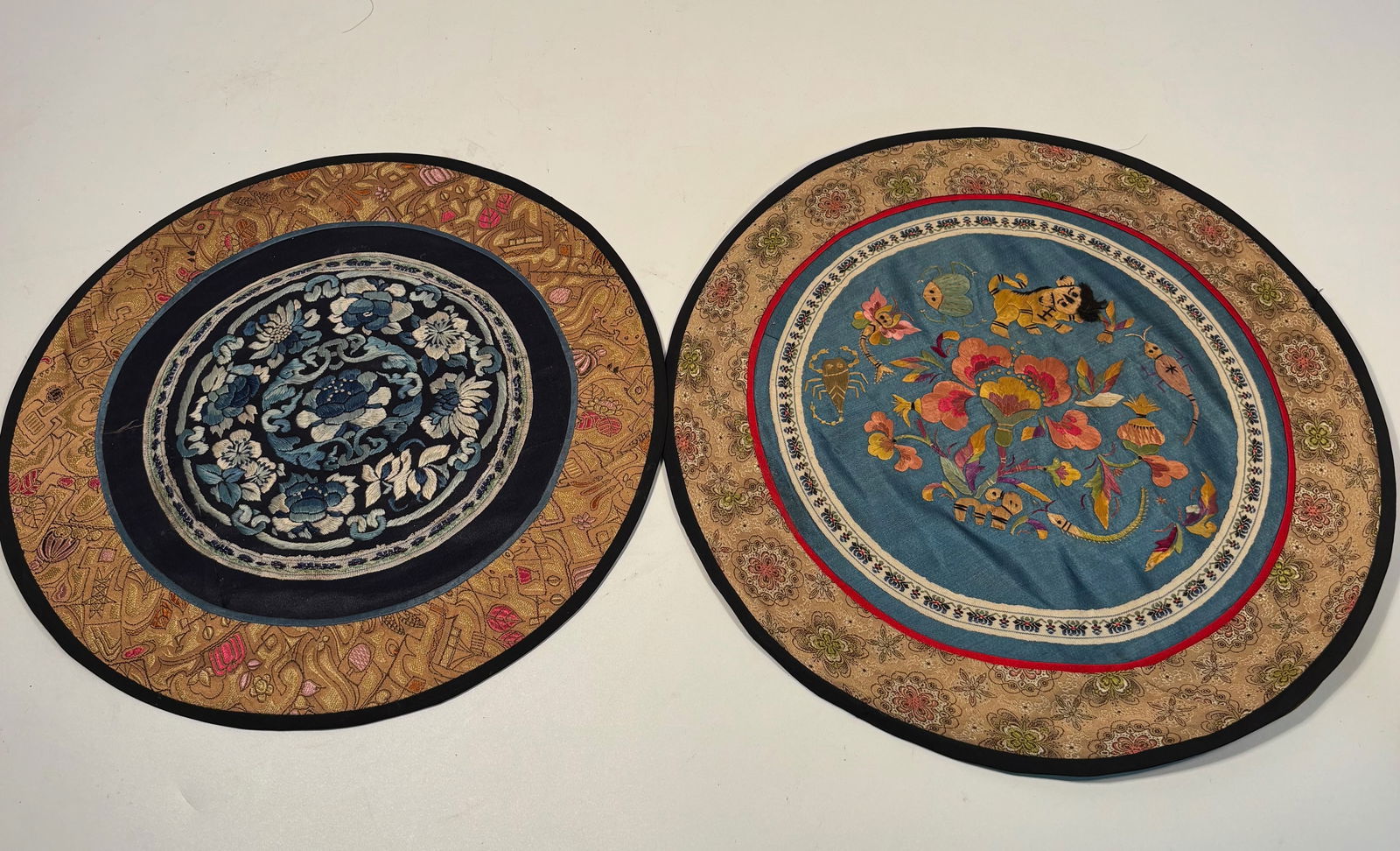 Set of 2 Chinese Embroidered Silk Roundels , Late Qing to Republic Period: Late 19th century to early 20th century; finely embroidered Chinese silk roundels, each worked in satin and couching stitches on dark silk grounds. One depicting peonies and chrysanthemums amid scroll