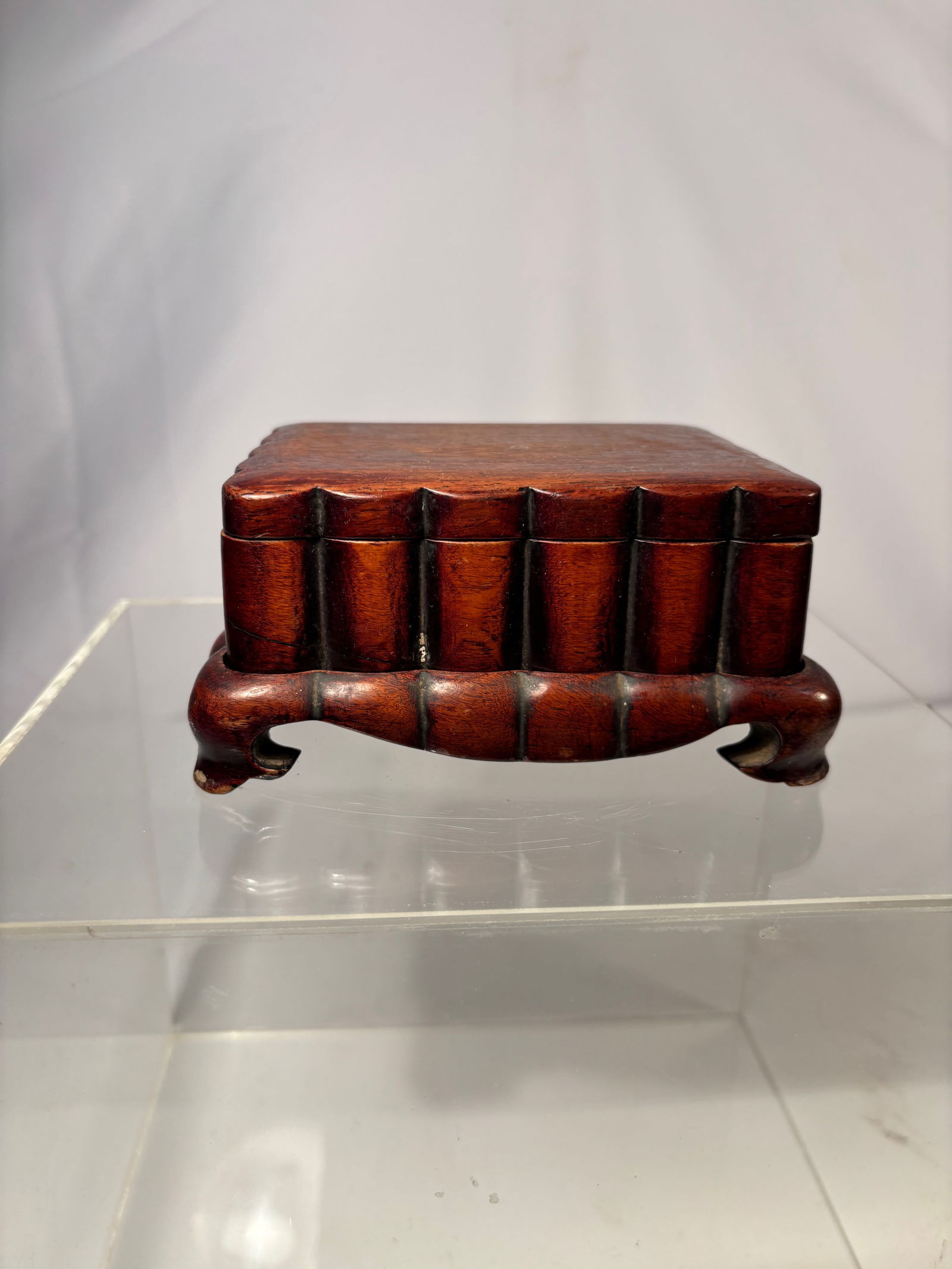 A fine Chinese hardwood/ huanghuali Scholar’s Box on Hardwood Stand: Qing dynasty(1644-1912); Rectangular Chinese hardwood/Huanghuali scholar’s box with a fitted cover, raised on a conforming openwork stand. The box features a smooth patina and well-proportioned