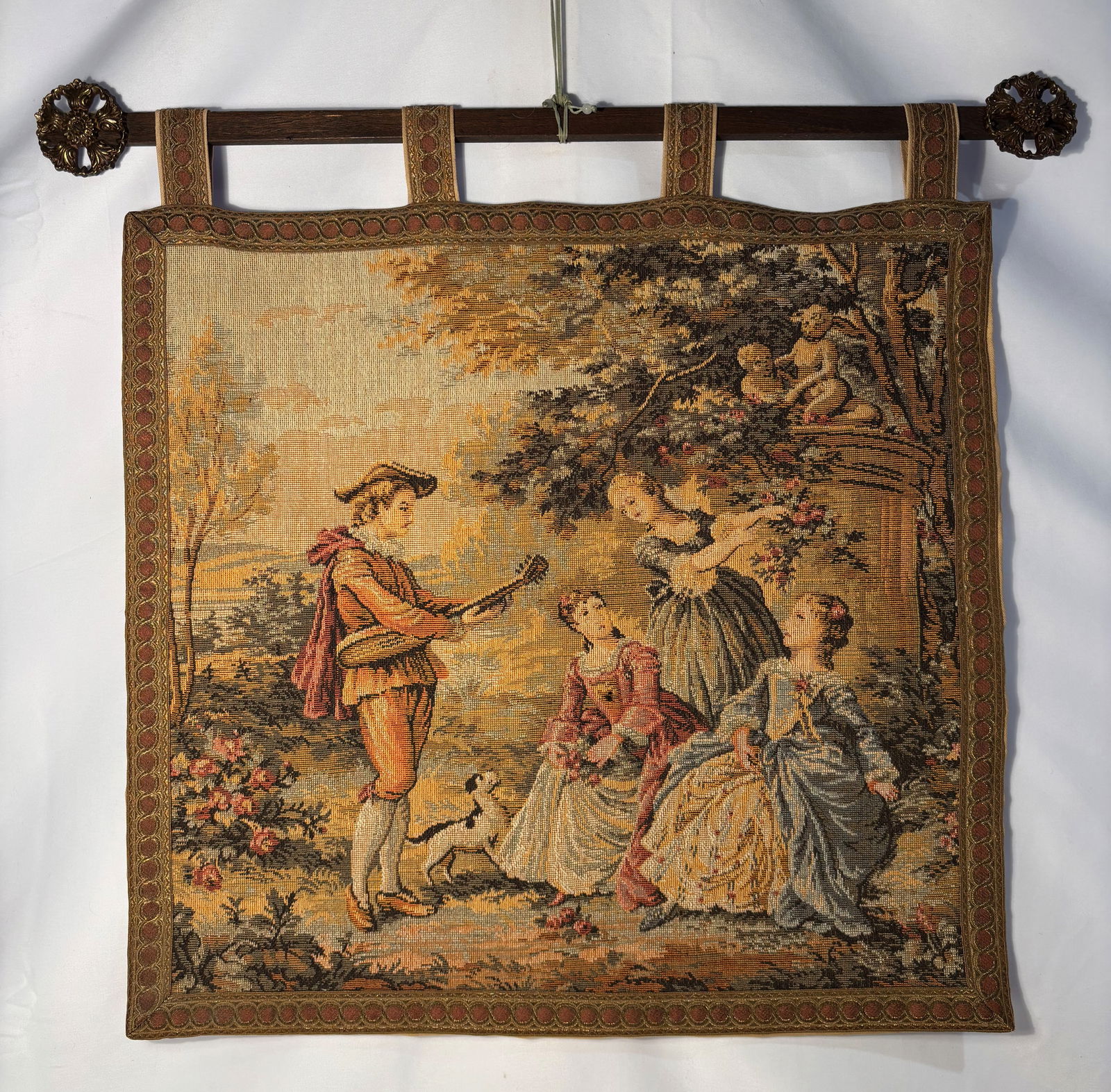 A French or Flemish Pastoral Tapestry Hanging with Figures, 18-19TH CENTURY: Continental European pastoral tapestry or needlework wall hanging, late 18th to early 19th century, depicting an outdoor figural scene with musicians and elegantly dressed figures in a landscaped sett