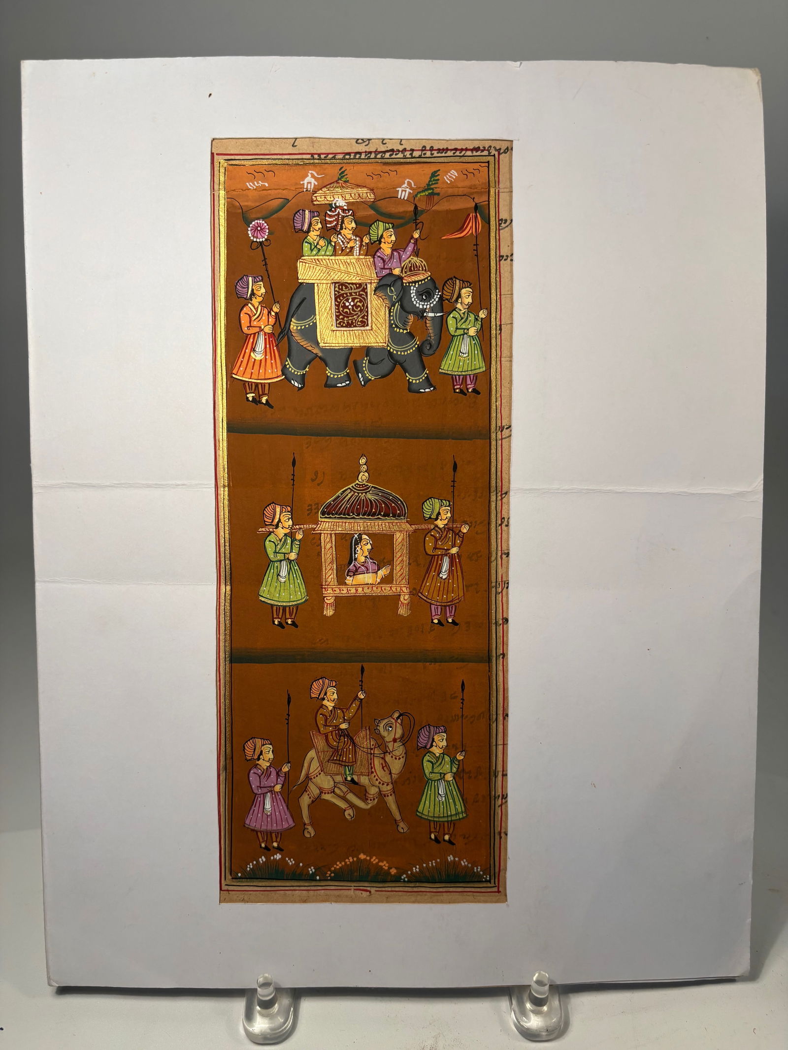 A Rajasthan School Miniature Painting, India with sign: 18th-19th century, The upper panel depicts a richly adorned elephant carrying nobility beneath a parasol, surrounded by attendants bearing fans and flags. The central panel shows a noblewoman in a pal