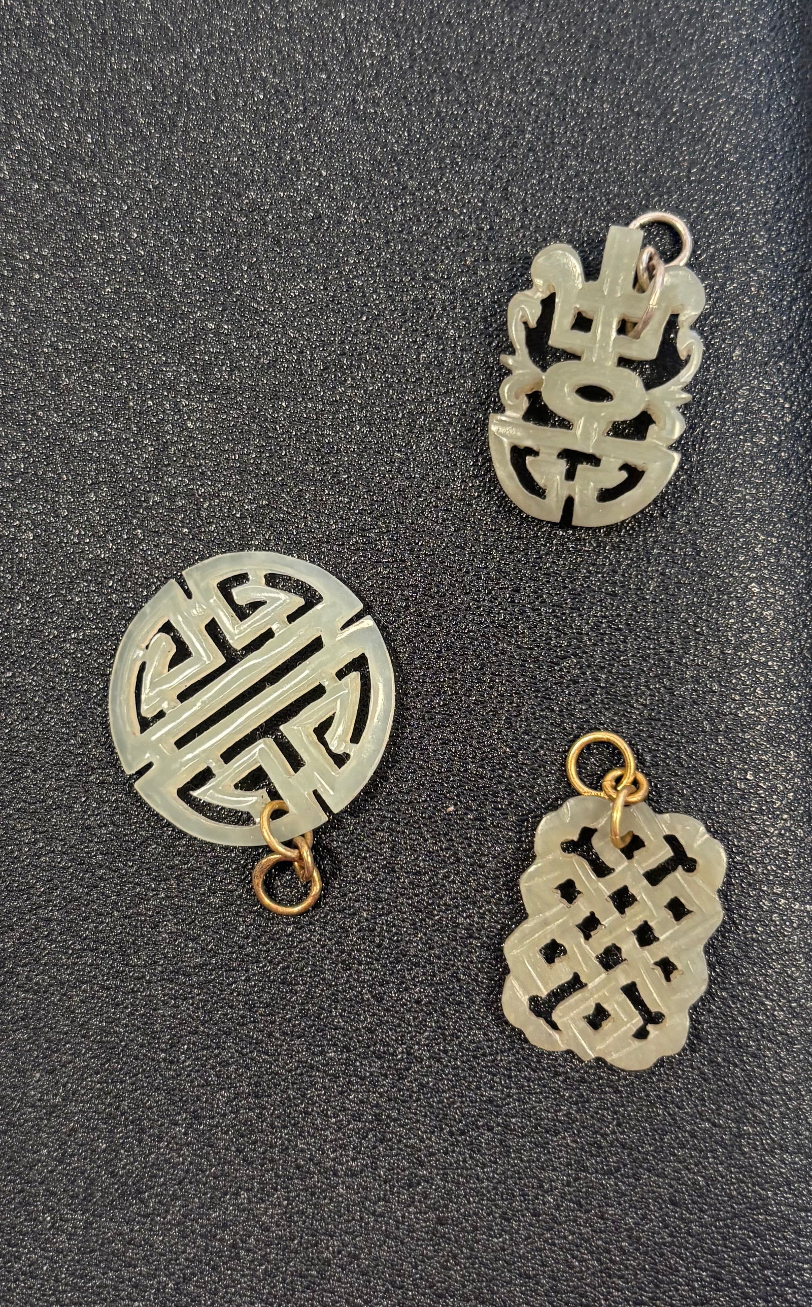 Set of three Chinese carved jade pendent: 19th Century; nephrite jade, soft greenish-white tone , featuring traditional auspicious symbols and characters.Dimensions? Length: 2.7 cm