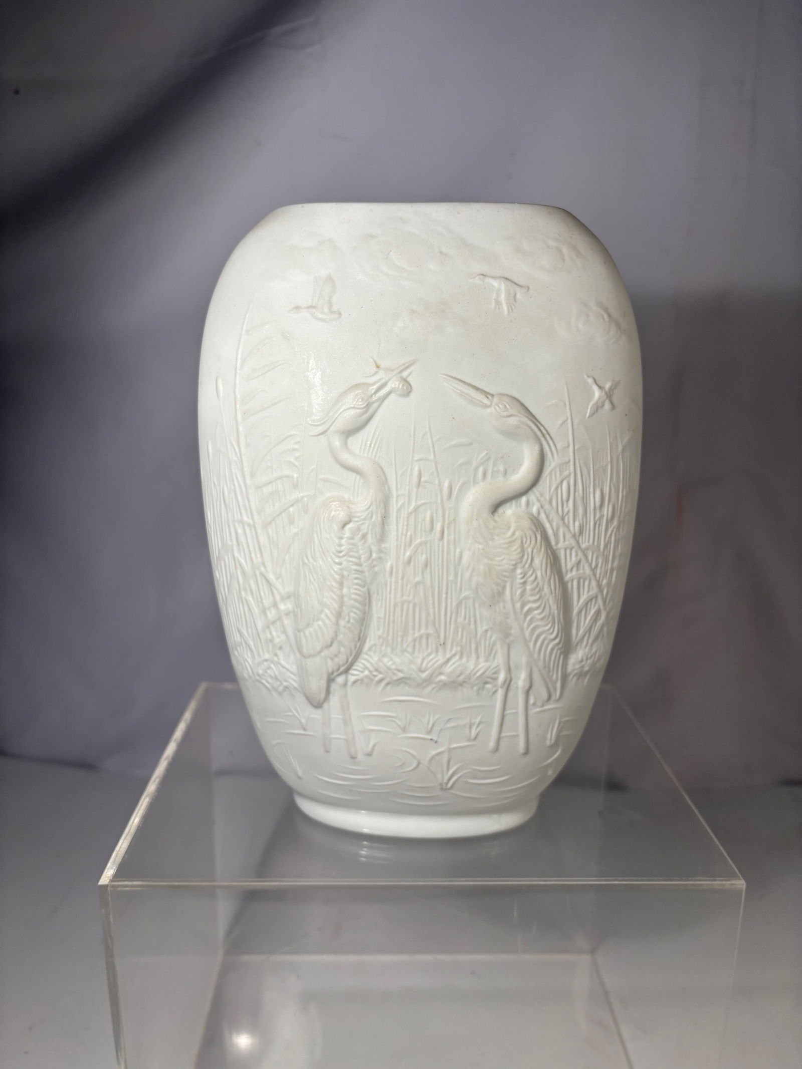 A Royal Porzellan Bavaria KPM Germany Porcelain Relief Vase: German porcelain vase by Royal Porzellan Bavaria (KPM), featuring molded relief decoration of cranes in a marsh landscape. Marked on underside “Royal Porzellan Bavaria KPM Germany Handarbeit.”