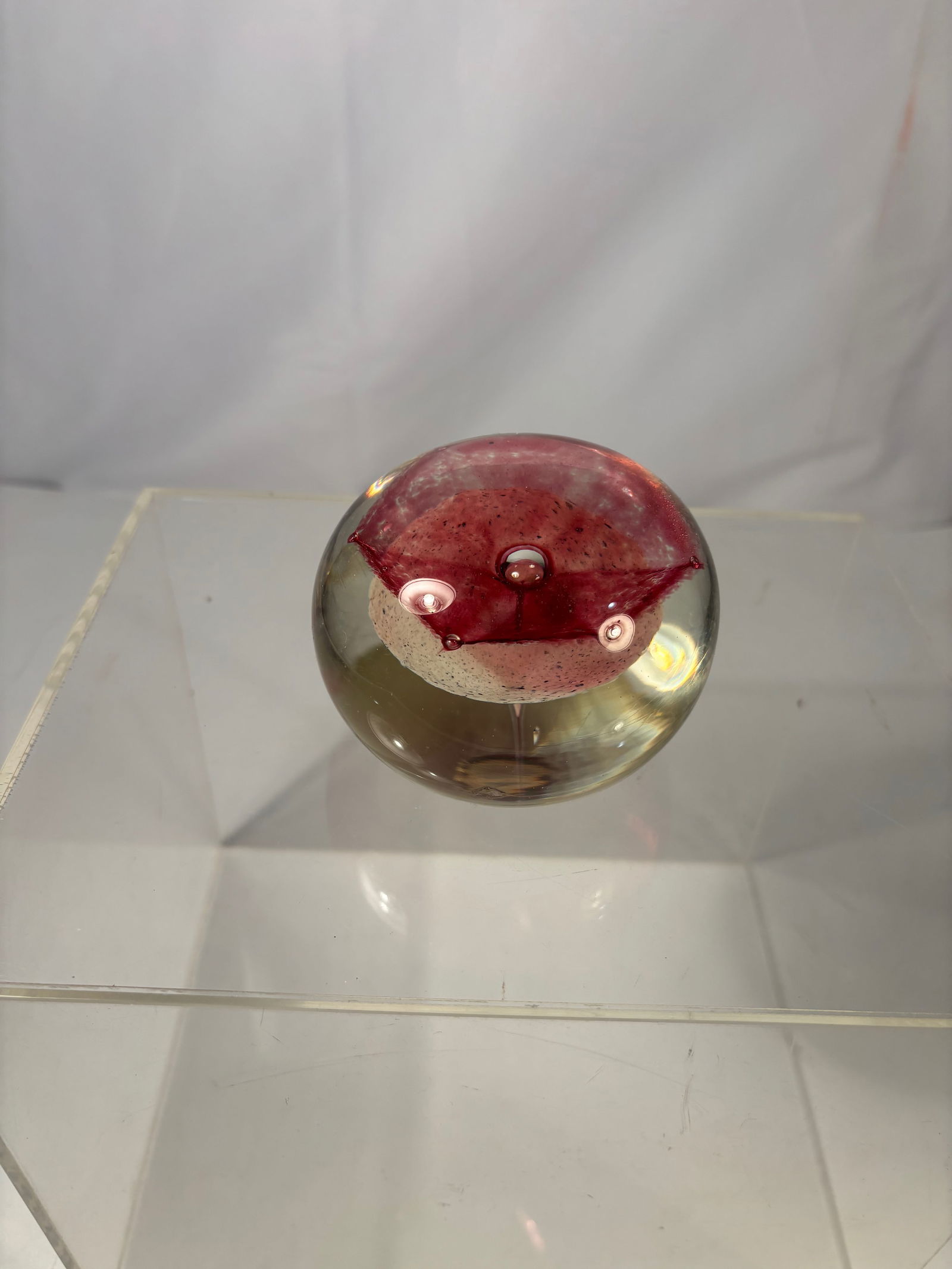 Terry Bloodworth S.D.C. Studio Art Glass Paperweight Pink Flower Splash: Terry Bloodworth (American, 20th century) S.D.C. Studio Art Glass Paperweight. The spherical form encasing a suspended pink flower splash design, centered with a metallic orb and vertical clear stem e