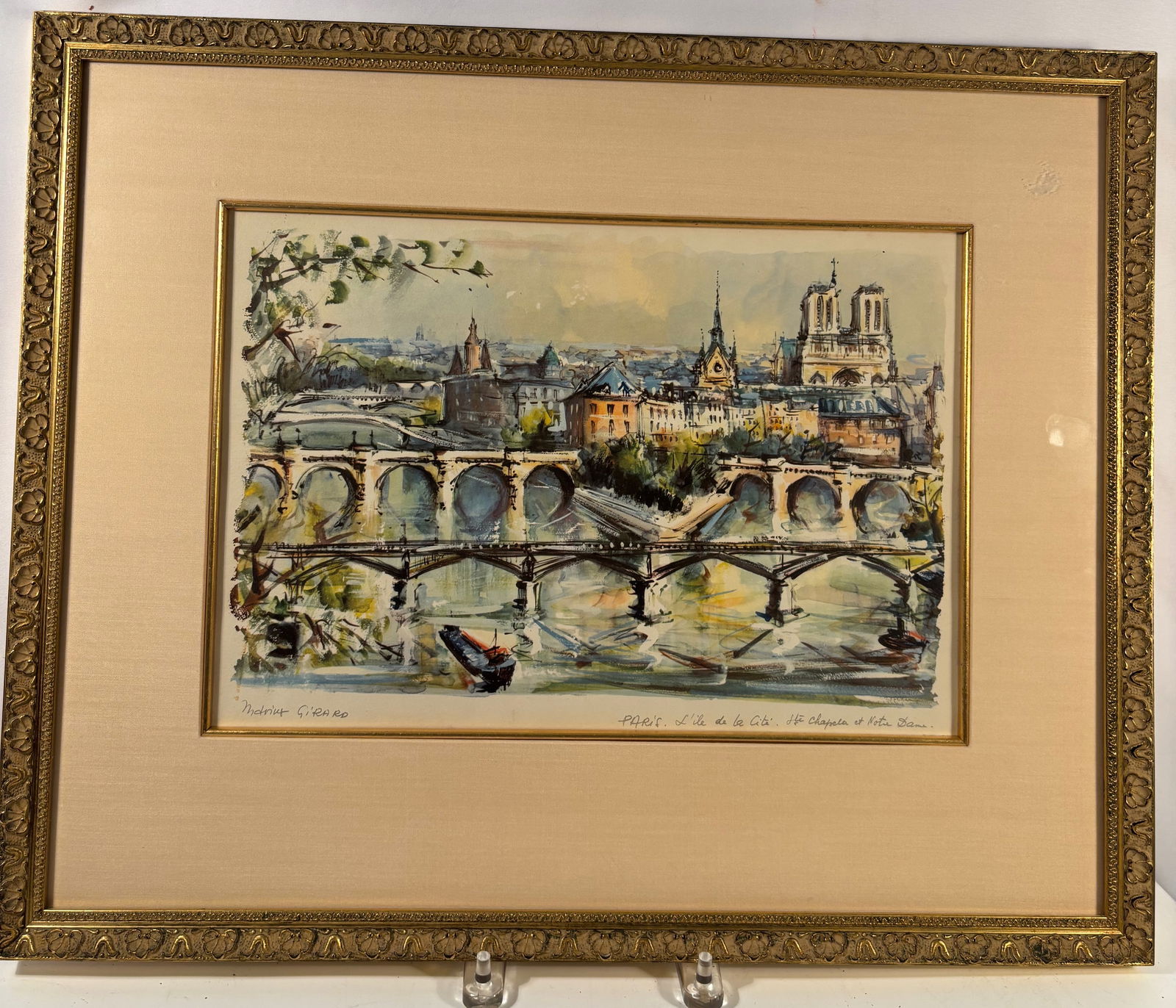 Marius Girard Signed Paris L'Ile de la Cité Sainte Chapelle Watercolor: Watercolor painting depicting a Paris cityscape view of L’île de la Cité with references to Sainte-Chapelle and Notre Dame. The composition features a bridge across the Seine with boats and surrou