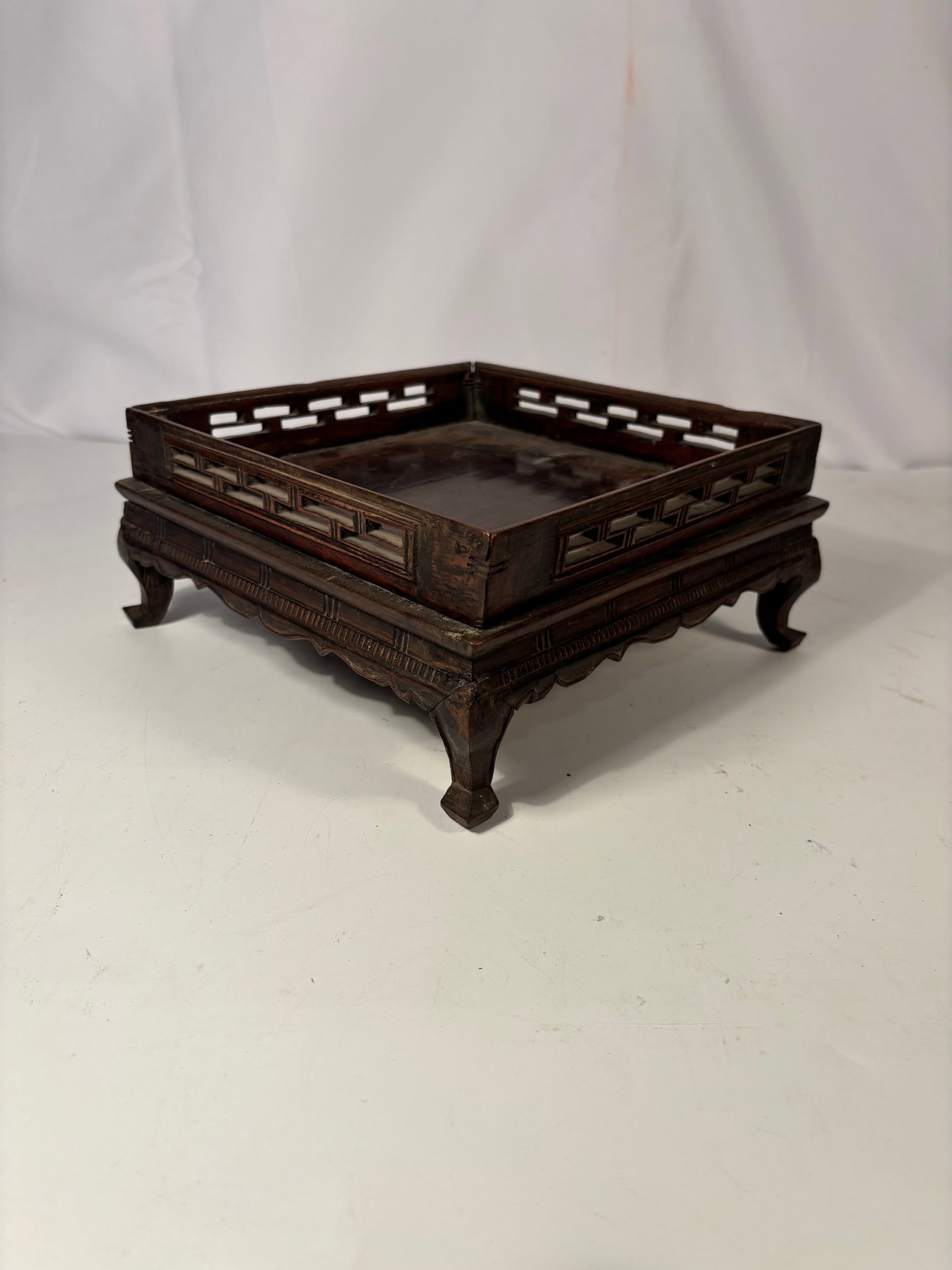 A Chinese Rosewood Display Stand with Openwork Gallery: 19th century, Chinese rosewood display stand featuring a recessed tray top with openwork gallery sides in a geometric pattern. Raised on four curved legs with a shaped apron. Suitable for displaying a