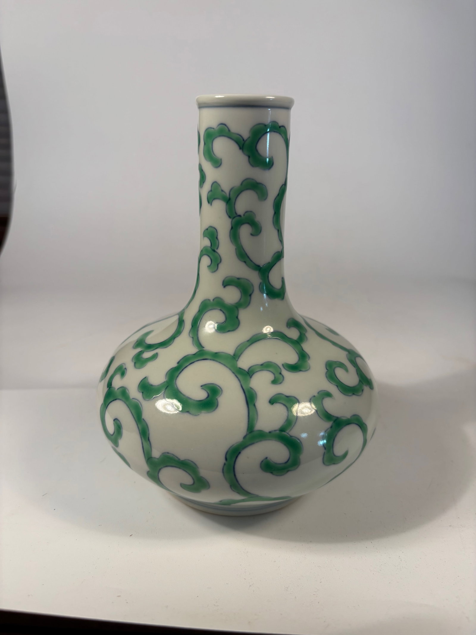 A Chinese Porcelain Vase with Green Enamel Scrolls marked " Chenghua" six characters: Qing Dynasty(1644-1912);A porcelain vase decorated in vibrant green enamel over underglaze blue outlines, depicting continuous scrolling foliage over a white ground. The form features a bulbous lower