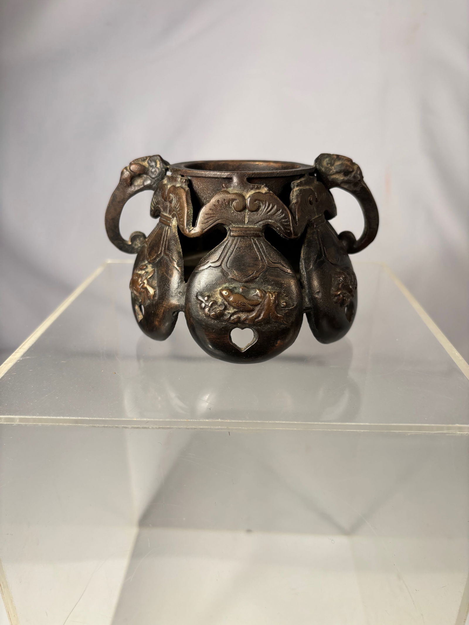 A Japanese Bronze Censer, Xuande Mark, Marked Japan: 19th Century ; A Japanese bronze censer with relief decoration and loop handles. The base bears a Xuande mark and is additionally stamped “Japan,”. Height: 3 inches; Diameter: 3.75 inches.