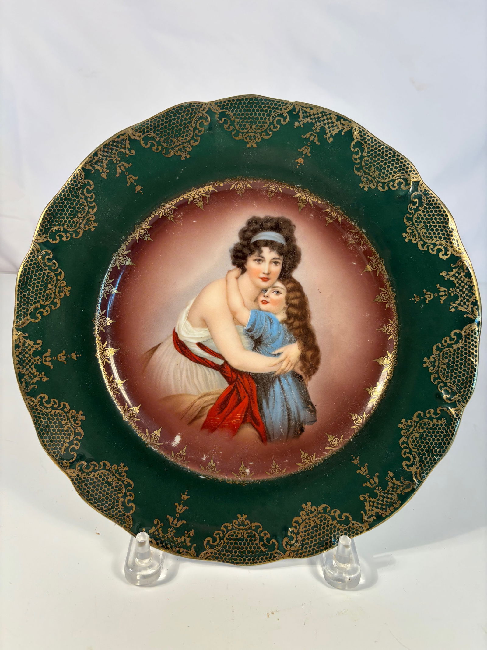 R.S. Prussia Porcelain Plate with Woman and Child Scenic Decoration: Early 20th-century R.S. Prussia porcelain plate, the center finely decorated with a scenic image of a woman and child in a pastoral setting, framed by a molded and gilded border. Reverse with the crow