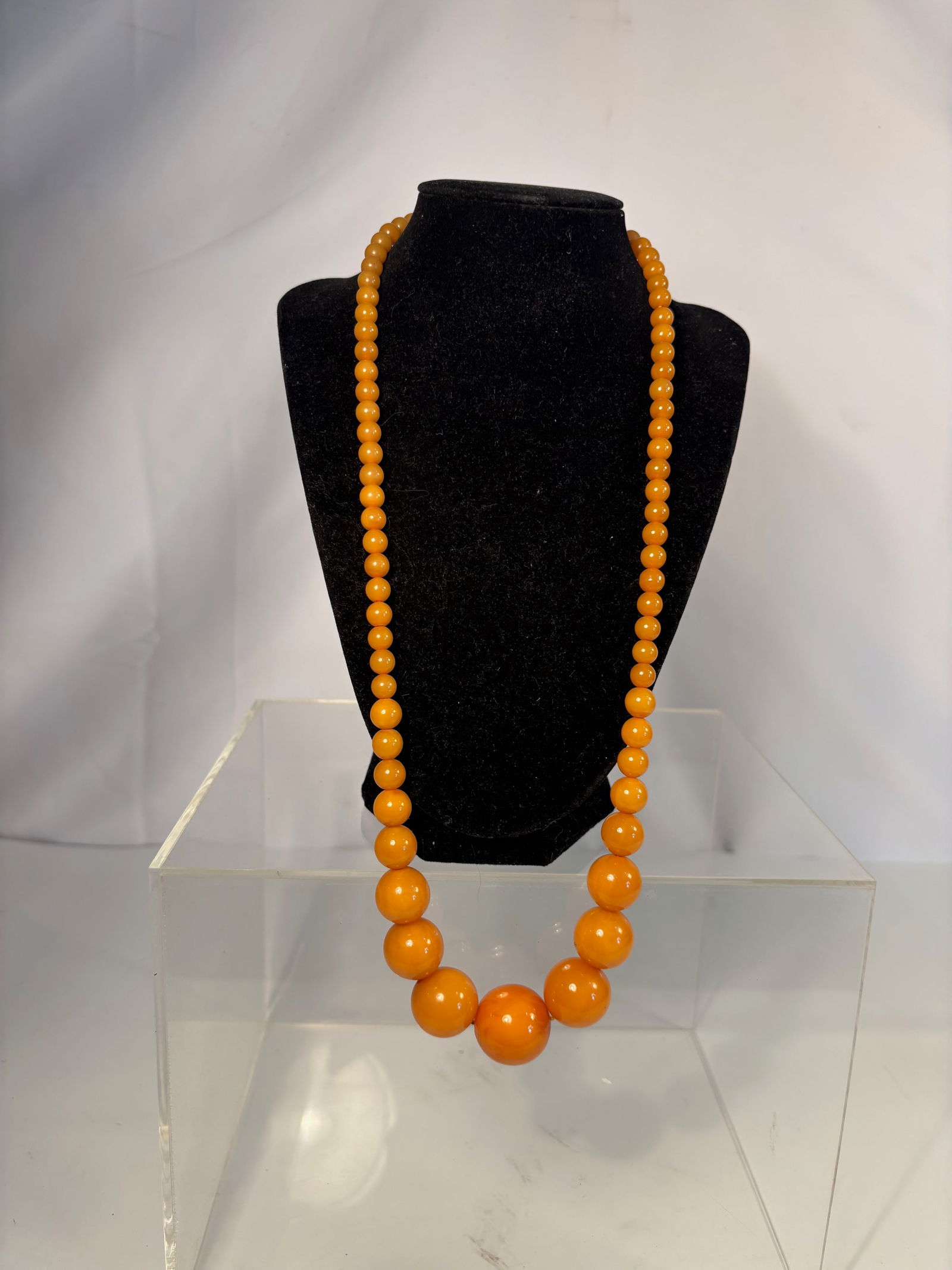A Graduated Butterscotch Amber Bead Necklace, 27.5 Inches, 2.30 oz: A beautiful graduated necklace composed of round butterscotch amber beads, displaying rich honey-yellow coloration with subtle natural variation and soft luster. The beads are arranged from smaller si