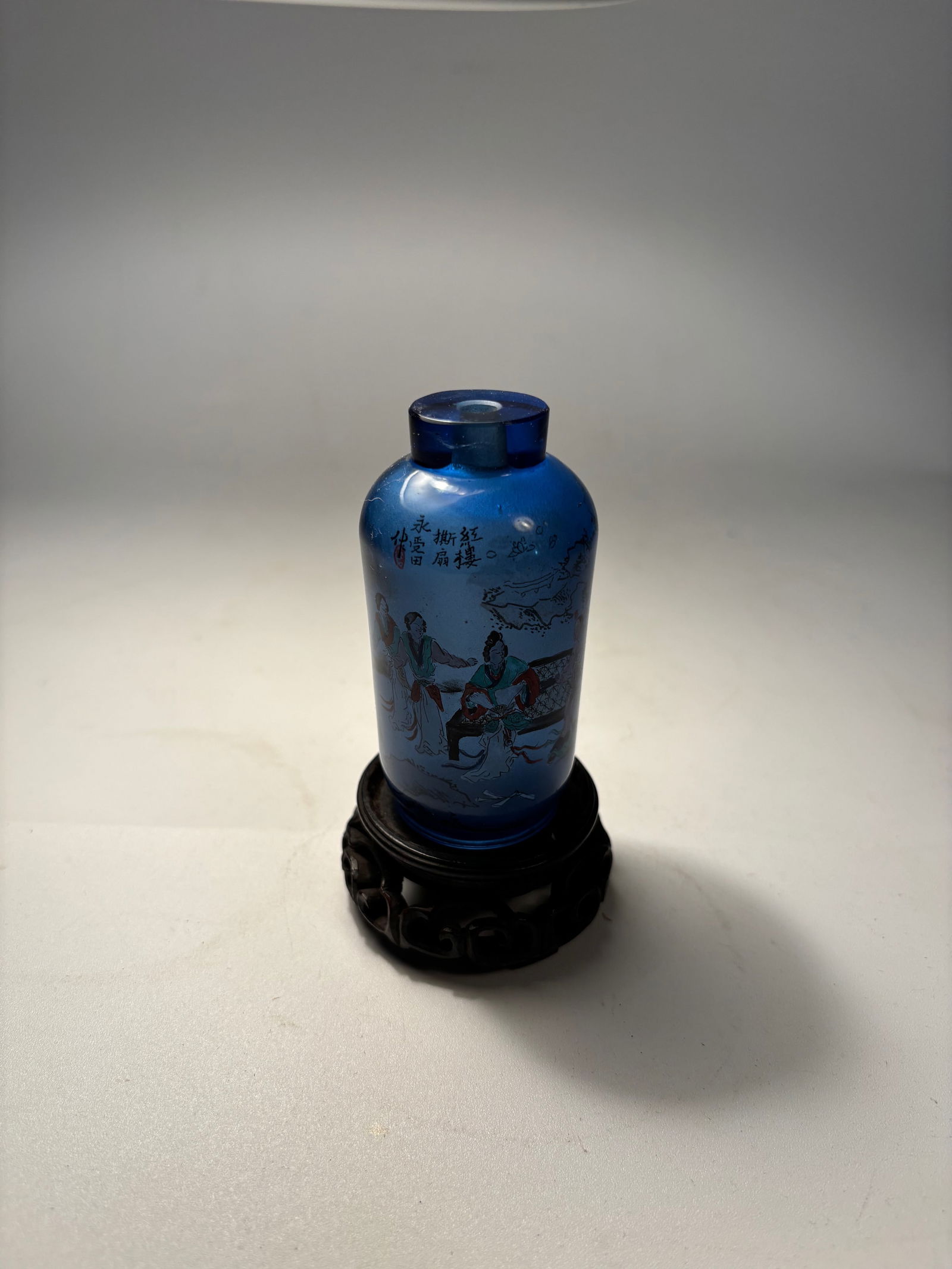 Reverse-painted Chinese Cobalt Blue Glass Snuff Bottle signed by "YONG SHOU TIAN": A beautifully crafted Chinese reverse-painted snuff bottle, made from vibrant cobalt blue glass, with interior painting showing court ladies in a garden, rendered in soft enamel tones. The reverse fea