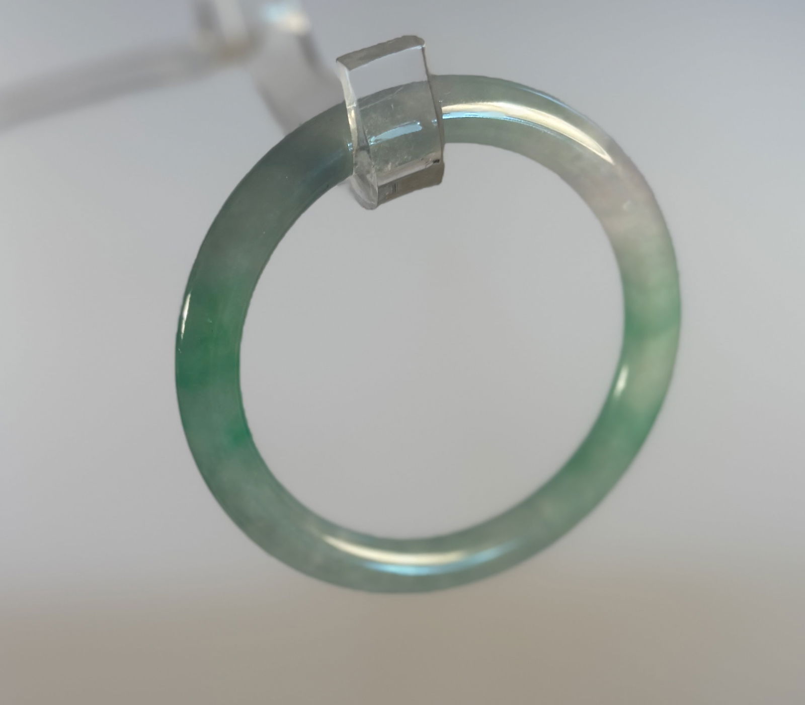 A Chinese jadited round solid bangle: Viaration from pale to medium green.Dimensions? Inside diameter: 63.8mm ; outside diameter: 84.2 mm .
