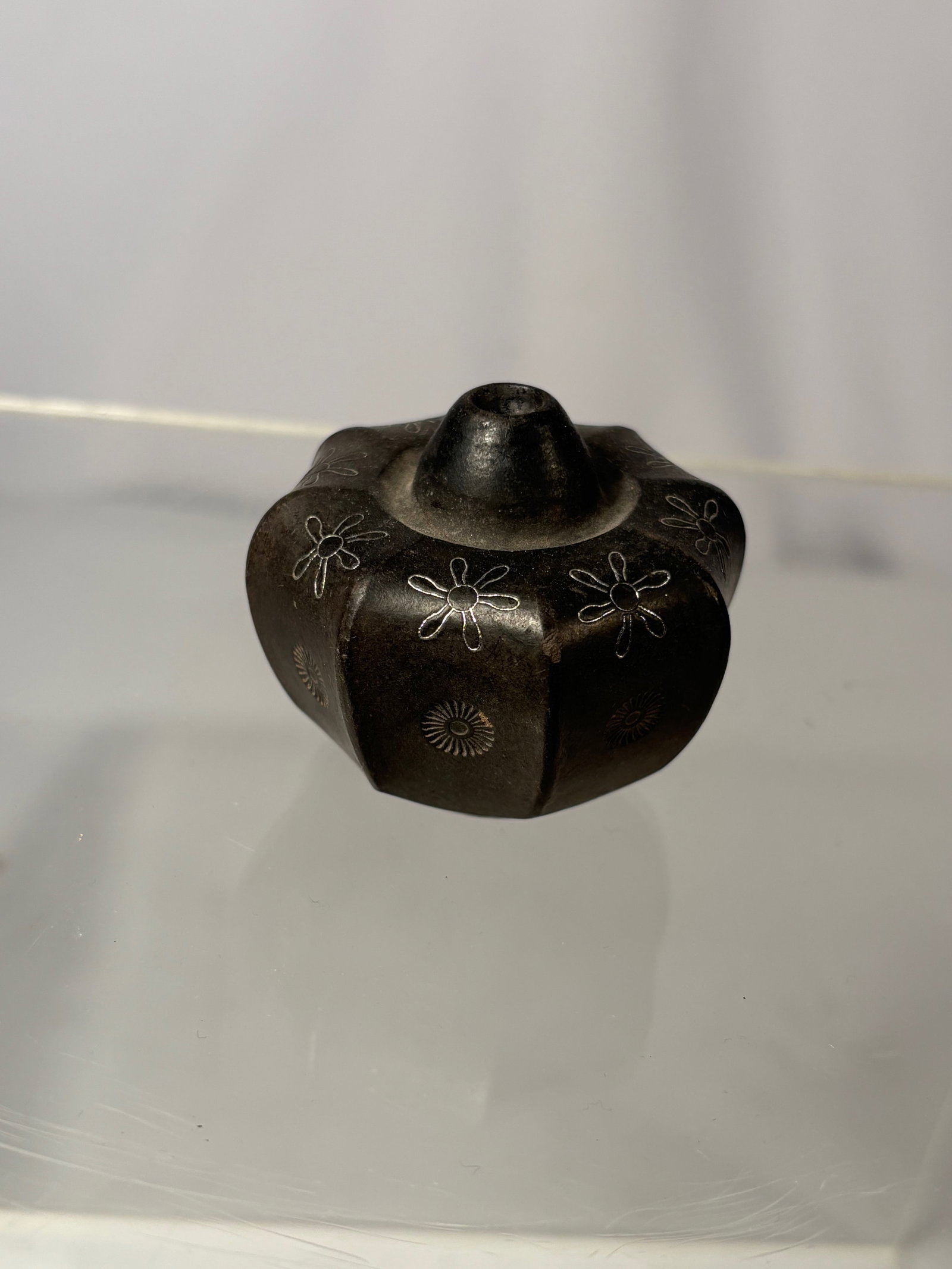 A Chinese Yixing Pottery Opium Pipe Bowl with Silver Inlay and Maker’s Mark: Late 19th to early 20th century; A Chinese Yixing pottery opium pipe bowl of faceted form, decorated with delicate silver inlay floral motifs around the body. and the underside bears an impressed make