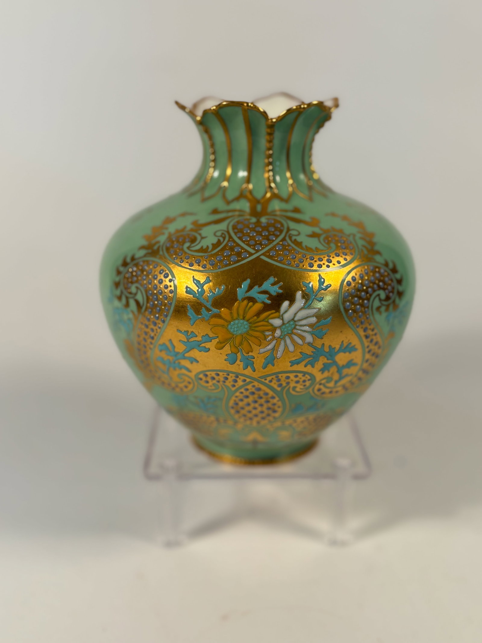 A Royal Crown Derby English Porcelain Vase, Green Ground with Gilt and Enamel Floral Decoration: c. 1900–1950”; A decorative porcelain vase by Royal Crown Derby, England, The baluster body rises to a fluted, gilded neck and is finished in a mint green ground with finely painted gilt carto
