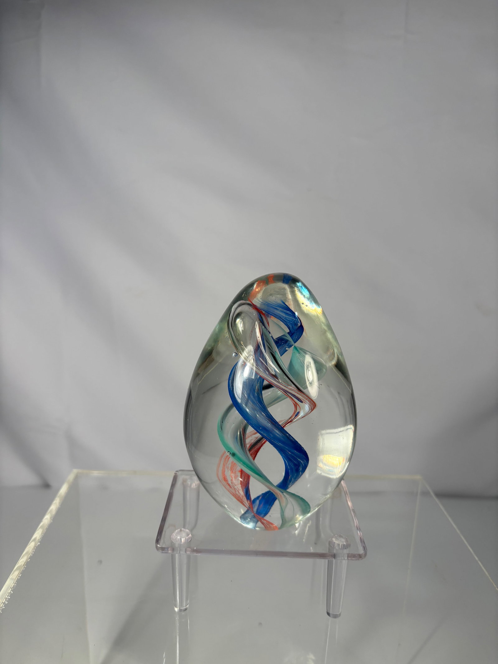 Art Glass Egg Paperweight with Red, Blue & Green Ribbon Swirls: Elegant Dynasty Gallery glass paperweight in an egg form, featuring vibrant red, blue, and green ribbon swirls gracefully twisting upward inside the clear glass body.Dimensions?qq
