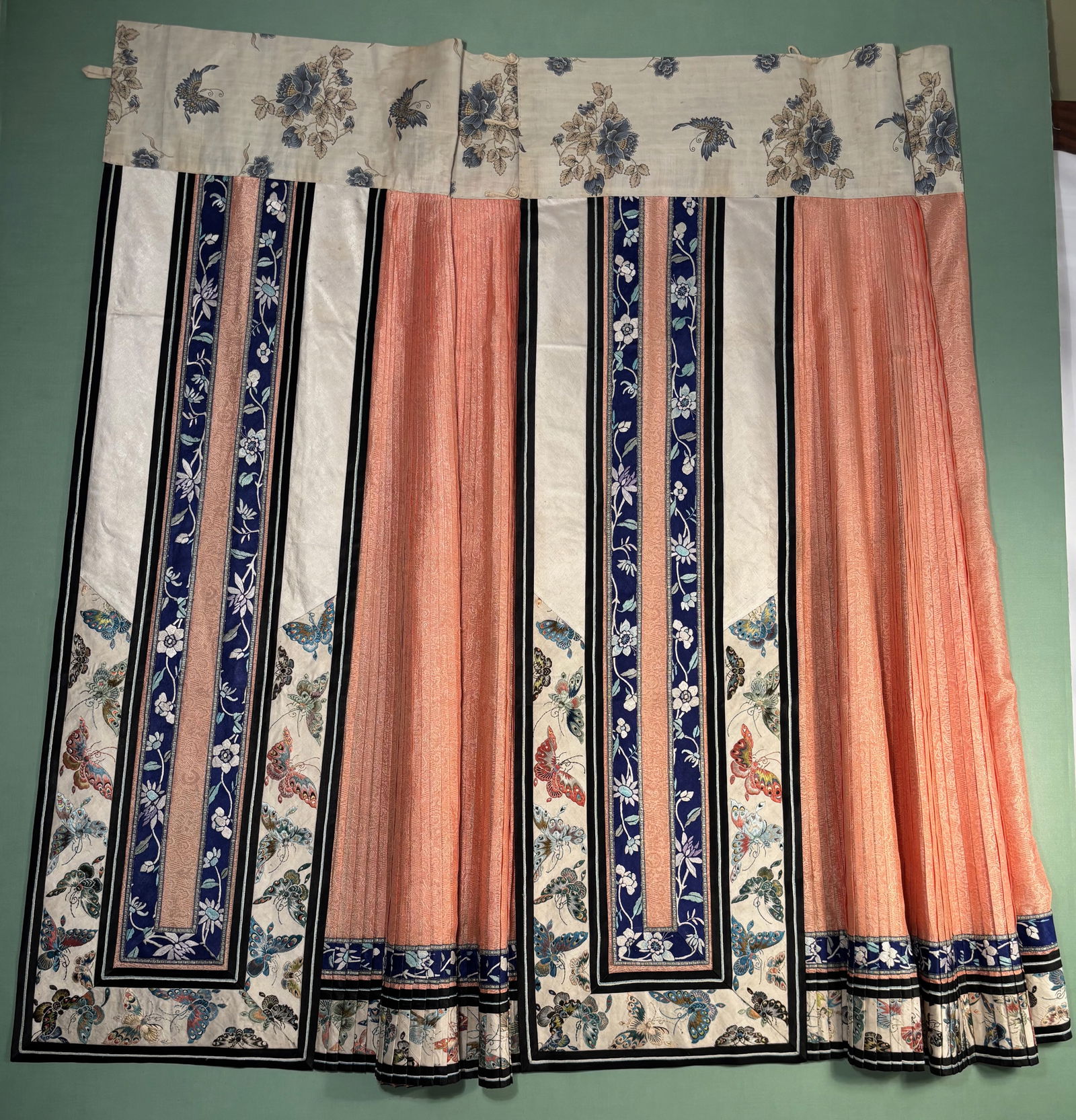 A Chinese Silk Ma Mian Qun (Horse-Face Skirt) with Butterfly Decoration: Qing Dynasty(1644-1912) ; Chinese silk Ma Mian Qun (horse-face skirt) featuring pleated construction with contrasting decorative panels. The skirt is adorned with woven butterfly and floral motifs in