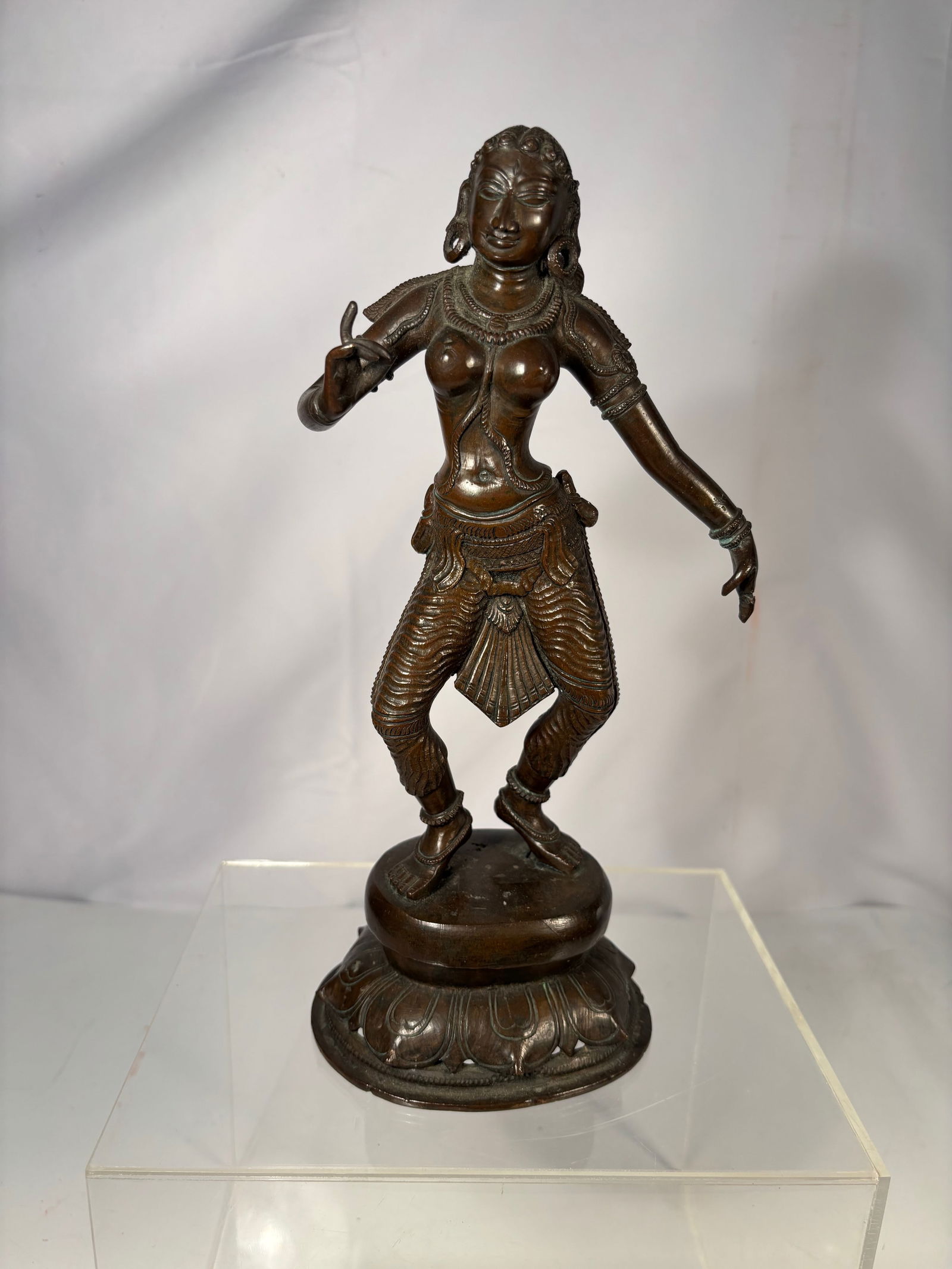 A Bronze Sculpture of a Dancing Hindu Goddess, Possibly Parvati or Dakini: 19th Century; Bronze sculpture depicting a dancing Hindu goddess, likely Parvati or a Dakini, shown in a graceful pose with expressive hand gesture. The figure is adorned with elaborate jewelry, armle
