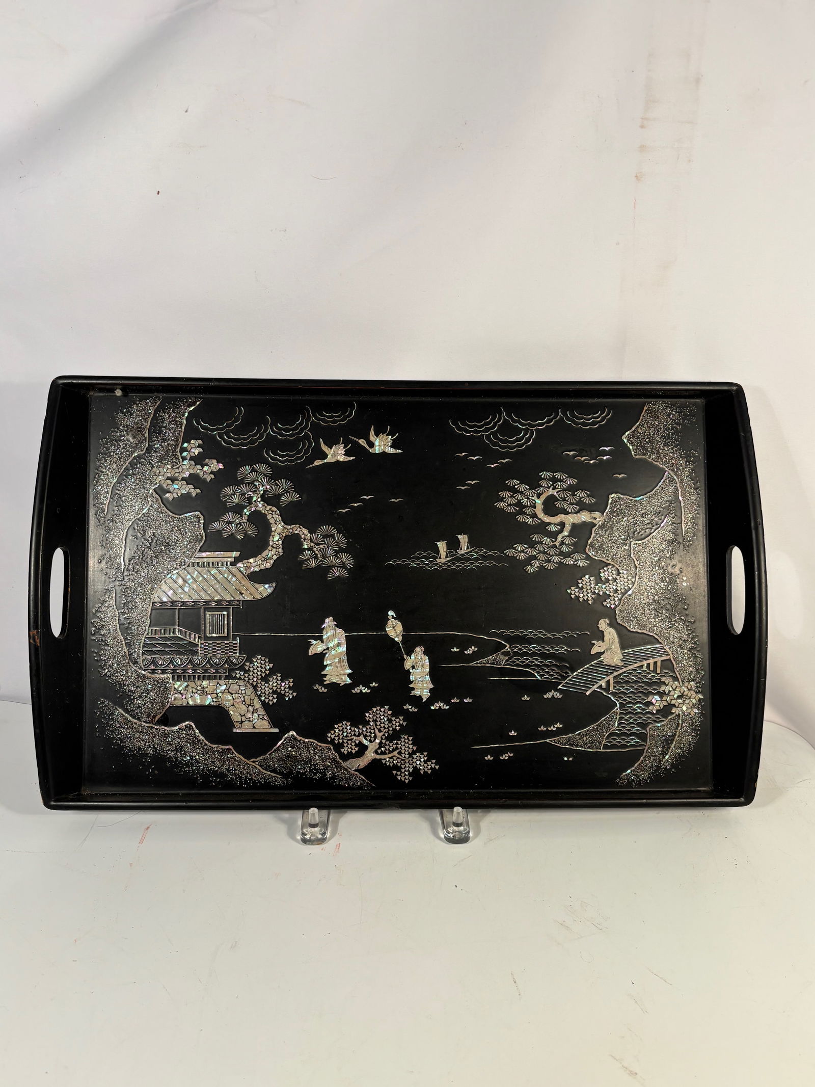 Chinese/Korean Black Lacquer tray with Mother-of-Pearl Inlay, Landscape with Figures and Cranes: Chinese black lacquer tray decorated with intricate mother-of-pearl inlay depicting a landscape scene with figures, cranes in flight, stylized trees, and architectural elements. The iridescent shell i