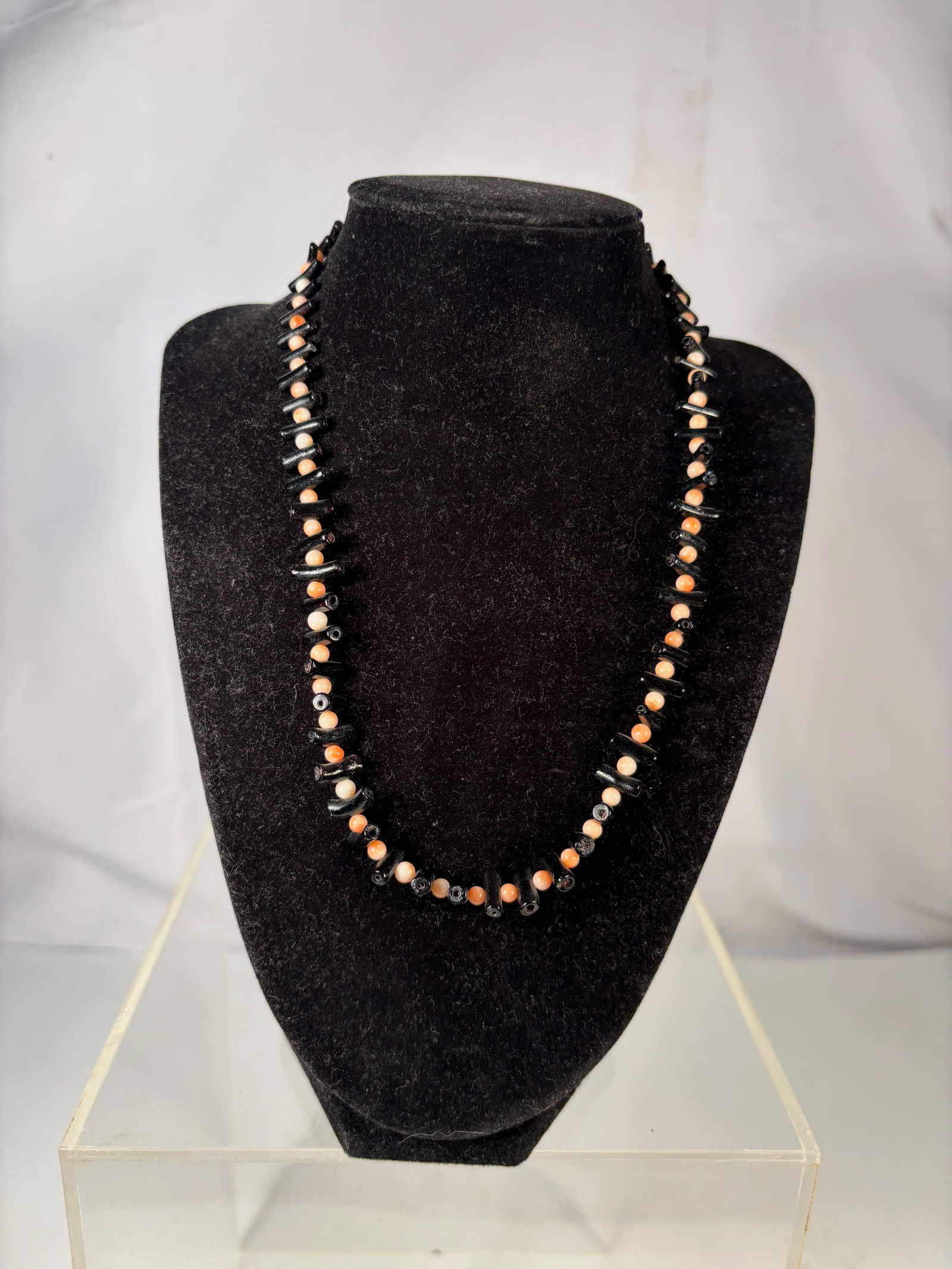 A Vintage Black Coral and Pink Coral Bead Necklace: Vintage necklace composed of alternating black coral branch beads and small pink coral round beads. The necklace finished with a decorative fish motif clasp. Necklace Length: 18 inches.