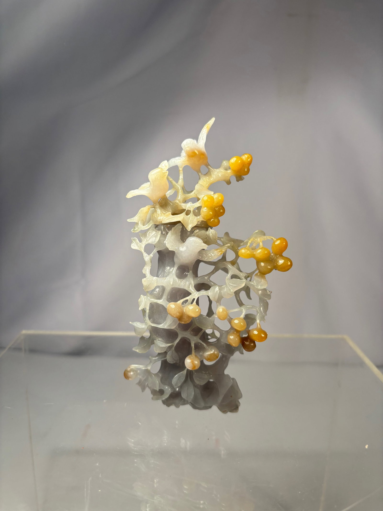 A Chinese Jadeite Vase, Lavender and Yellow Tones: Carved Chinese jadeite vase displaying lavender-toned areas with yellow coloration. The stone is worked in an openwork style with lingzhi and rock-form motifs, creating an organic, sculptural profile.