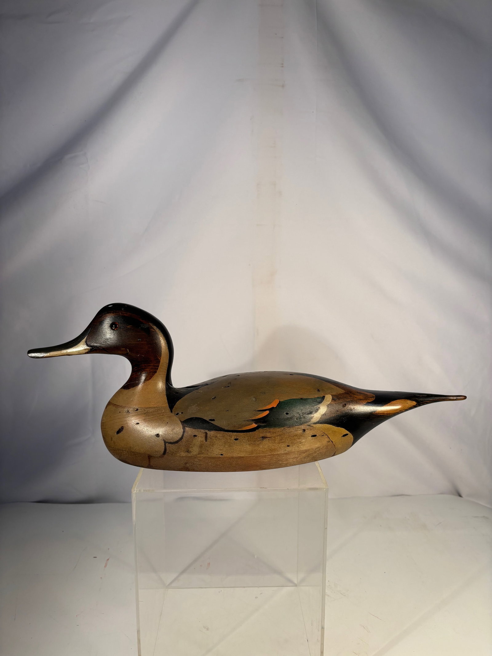 Signed Tom Taber Hand-Carved Wooden Duck Decoy: Hand-carved wooden duck decoy by Tom Taber , crafted in a decorative folk art style. The carving features a smoothly contoured body, elongated neck, and finely shaped head with painted eyes and