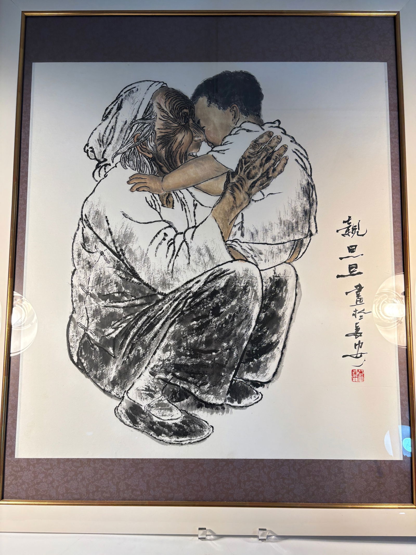 A Chinese ink and color painting of Elder and Child, Signed Qin Dandan: 20th century; Moving composition capturing a heartfelt embrace between a seated elderly woman and a child, rendered in expressive black ink with delicate watercolor highlights. The intimate moment ref