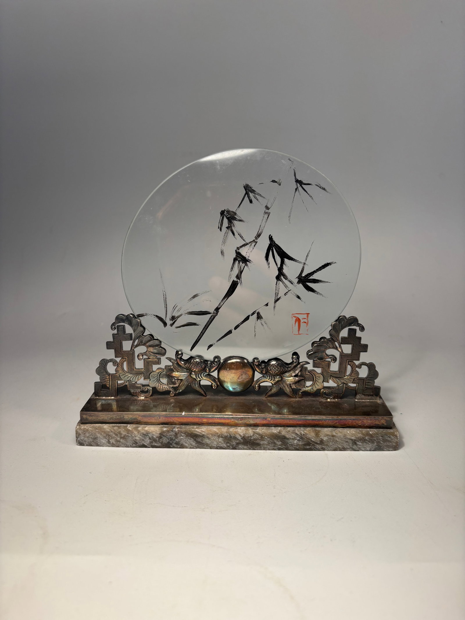 A Chinese scholar’s Silver-Mounted Miniature Table Screen with Reverse-Painted Bamboo Glass and: Qing dynasty(1644-1912); A rare and finely detailed Chinese scholar’s miniature table screen, featuring a round reverse-painted glass panel depicting bamboo in ink brush style, set within a delicate