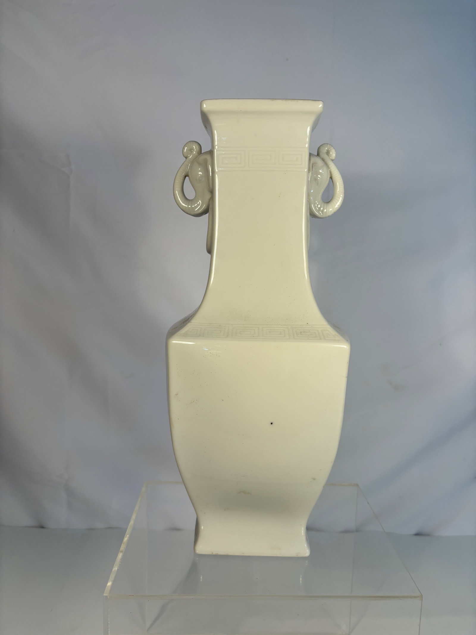 A Chinese Blanc-de-Chine Elephant-Handle Hu Vase: Qing Dynasty(1644-1912); The vase of archaistic hu form, with a tapering square-section body rising to a flared neck and everted mouth, set with a pair of elephant-head handles each suspending a fixed