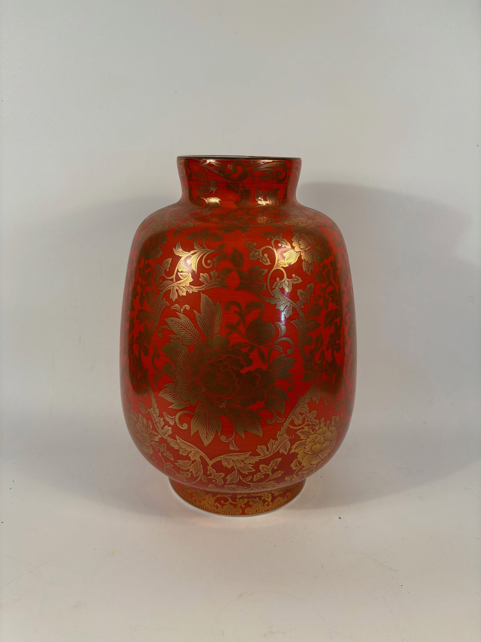 A Japanese Kutani Red & Gold Vase by Shibata Toki: 20th century, A Japanese porcelain vase with vibrant iron-red glaze, profusely decorated in raised gold floral scrolls featuring peonies and chrysanthemums. The base bears a red seal mark reading “D