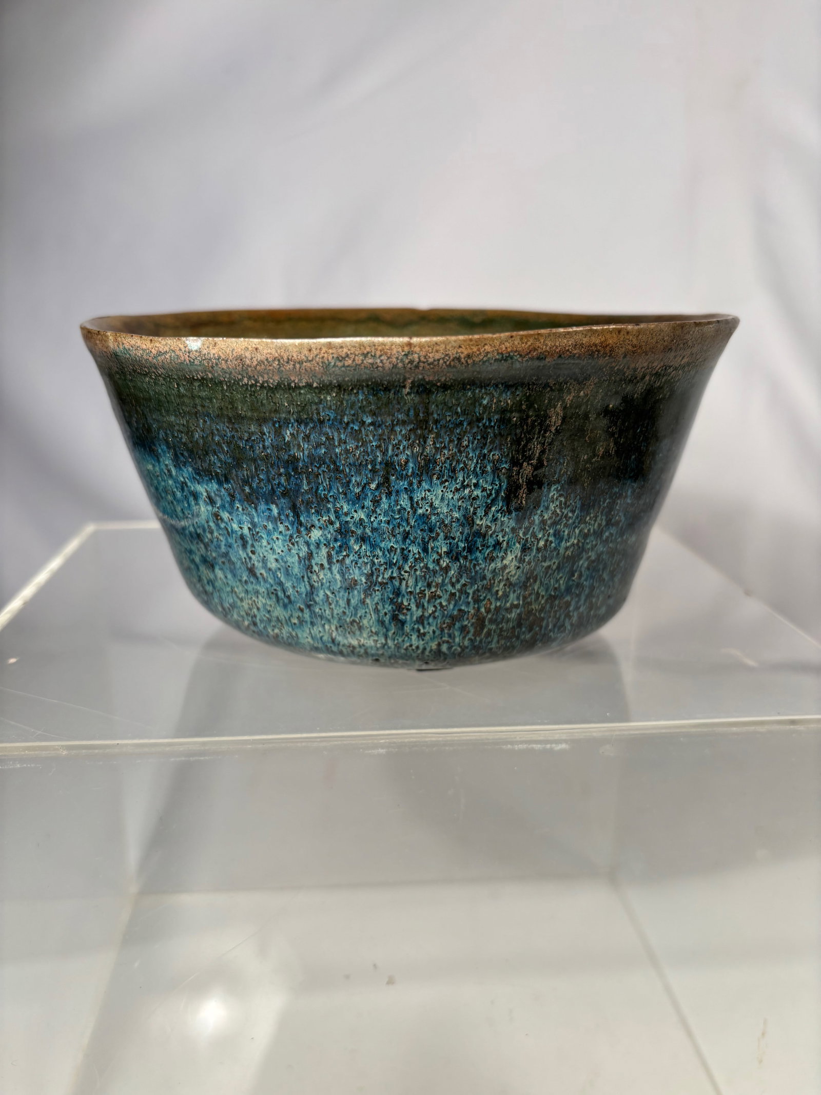 A Chinese Shiwan Pottery Bowl: Qing Dynasty(1644-1912) ; A Chinese Shiwan pottery bowl with blue and green flowing glaze. The bowl of slightly flared form with thick walls and a mottled glaze showing areas of metallic tone near the